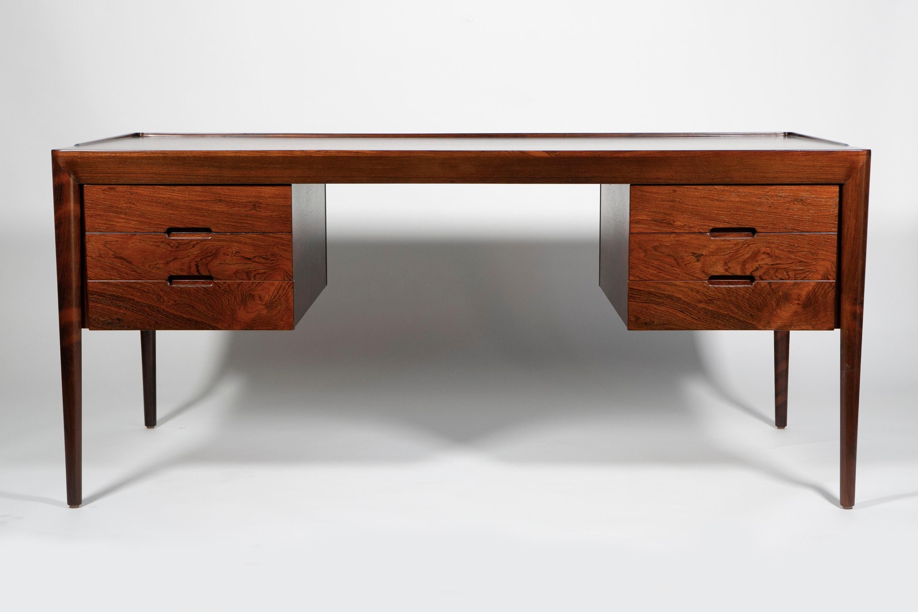 Rosewood Writing Desk, Erik Riisager Hansen, Haslev Mobelsnedkeri, Denmark, 1950s

This rare Rosewood writing desk by Erik Riisager Hansen for Haslev Mobelsnedkeri has a very elegant and sleek design with nice details. The beautiful thick banding