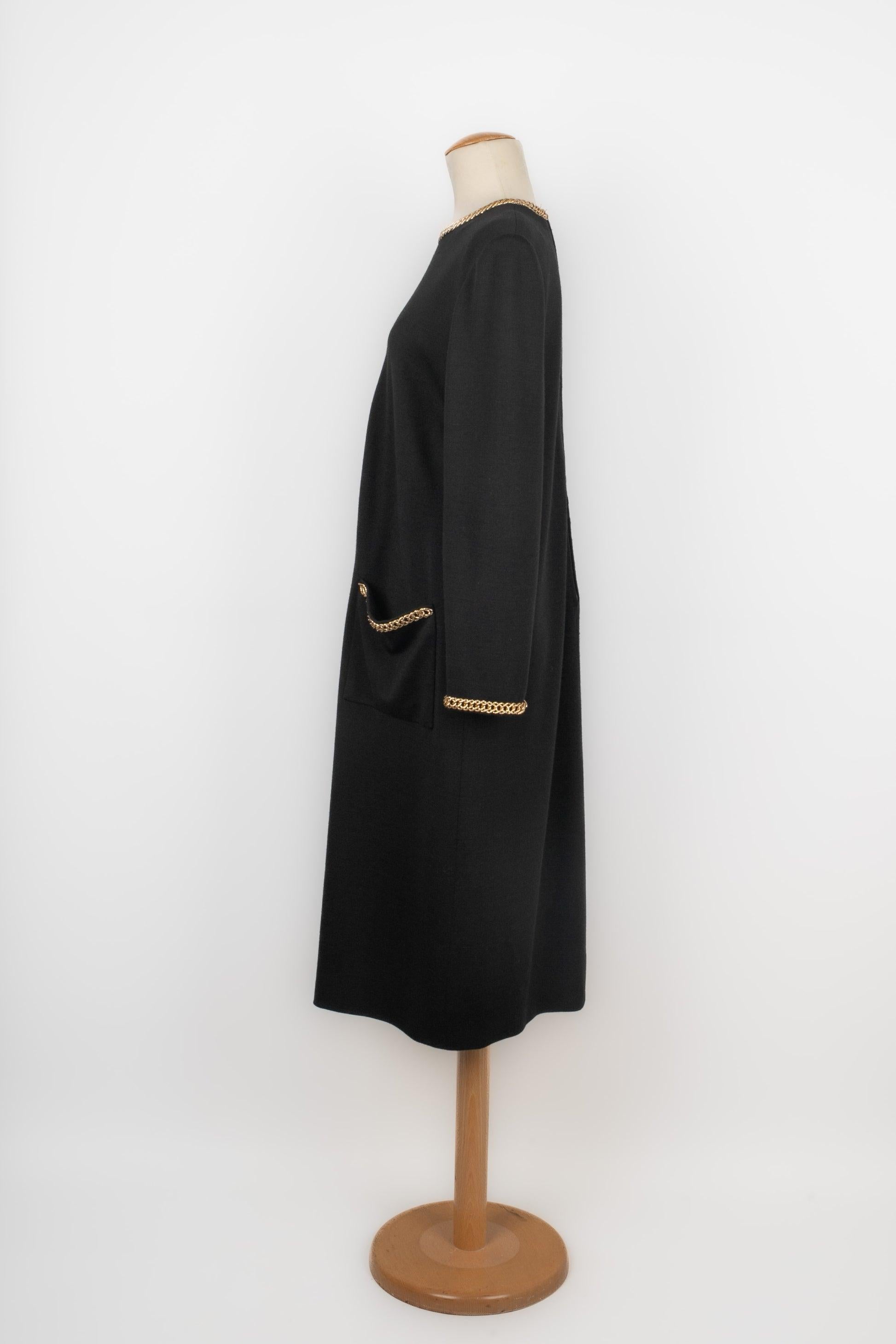 Erik Schaix  - Vestido de punto negro cosido con cadenas y un corazón de metal dorado. No se indica la talla, se ajusta a una 38FR.

Más información:
Estado: Muy buen estado
Dimensiones: Anchura de los hombros: 46 cm - Pecho: 50 cm - Longitud de las