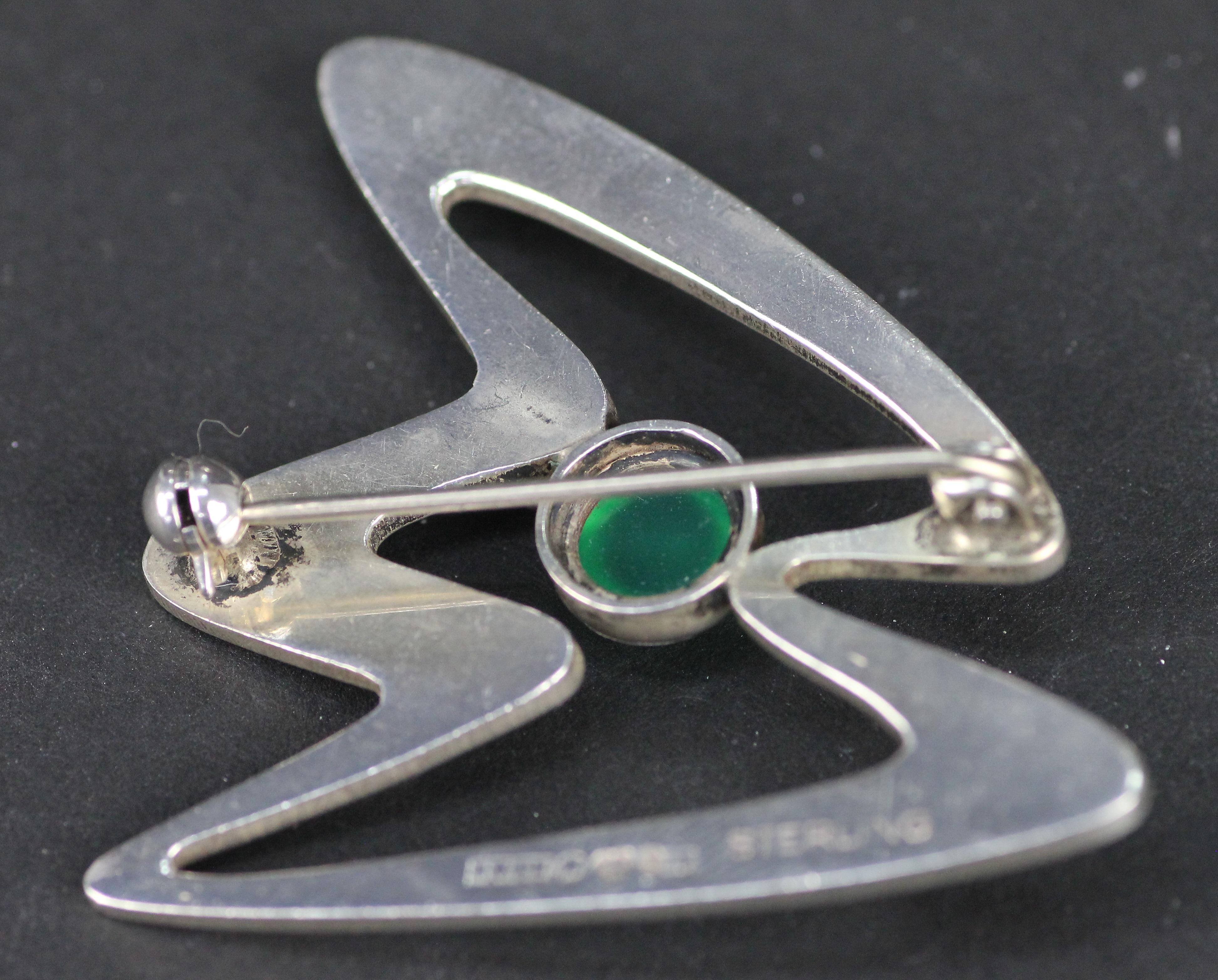 Swedish modernist Brooch. Made by Erik Svane in Helsingborg 1959.
Sterling silver with green cabochon-cut agate. 