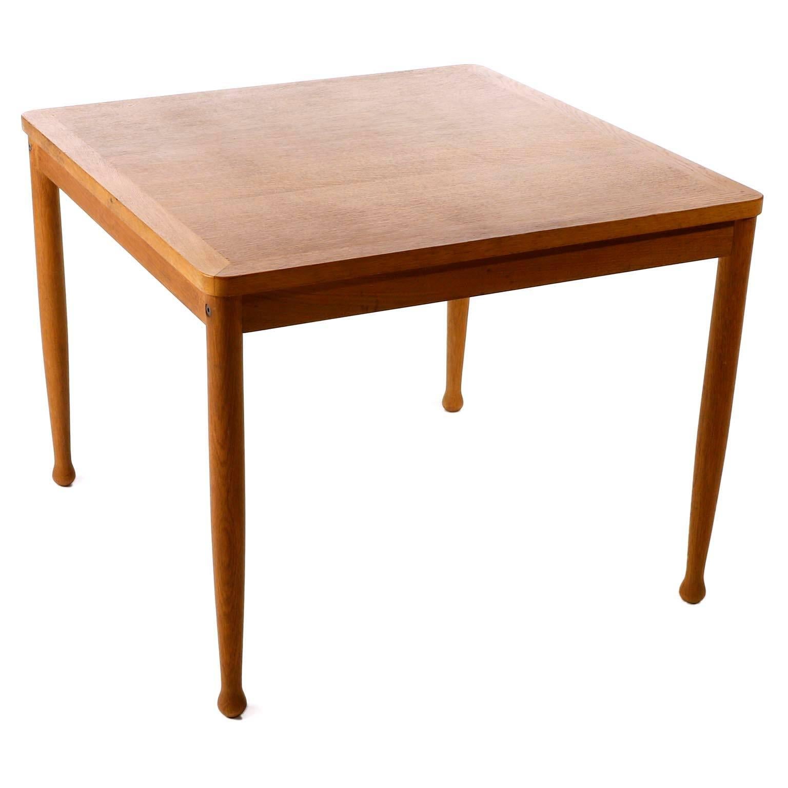 A square coffee table in a warm toned oak or elmwood designed by Erik Wørts for Niels Eilersen, Denmark, manufactured in midcentury, circa 1960 (late 1950s or early 1960s).
A great example of an organic shaped and simple and timeless designed