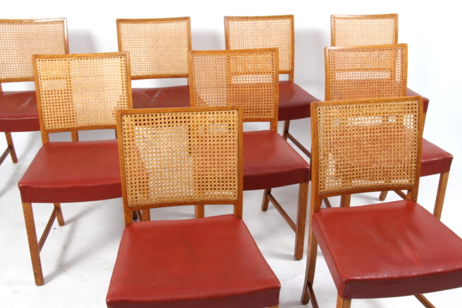 Erik Wørts nine dining chairs. Upholstered with red leather. Back with cane.

Frame of solid oak.

Made by Wørts møbelsnedkeri.
