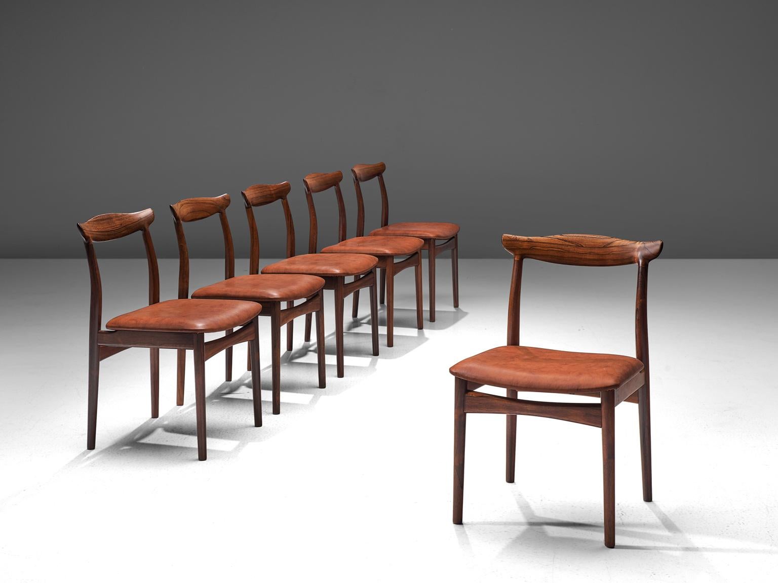 Erik Wortz for Vamo Møbelfabrik, set of six dining chairs model 112, rosewood and leather, Denmark, 1950s. 

Set of six dining room chairs in rosewood and recently reupholstered in brown leather. The four cylindrical legs are tapered and run over