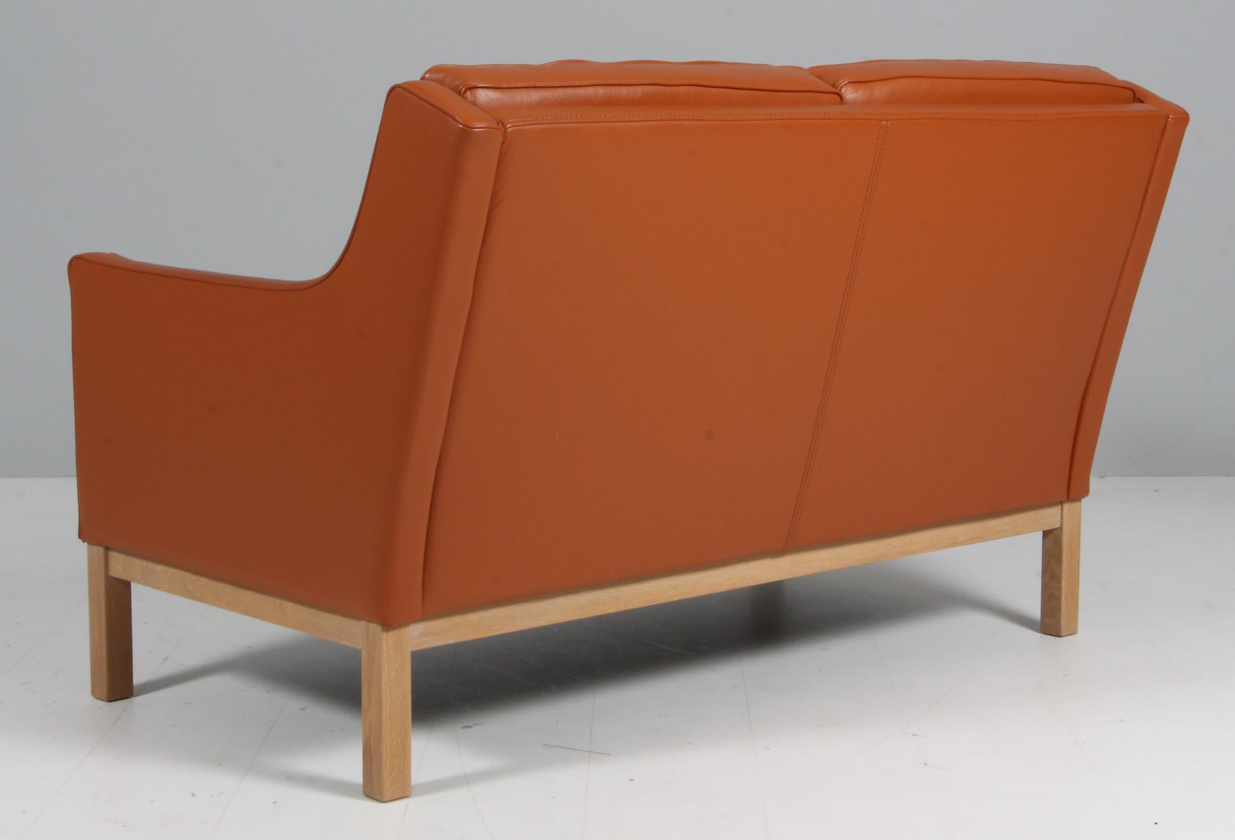 Divano a due posti di Erik Wørts con struttura in Oak. Tappezzeria originale in pelle color cognac. 

Modello L-601-2, prodotto da FDB.