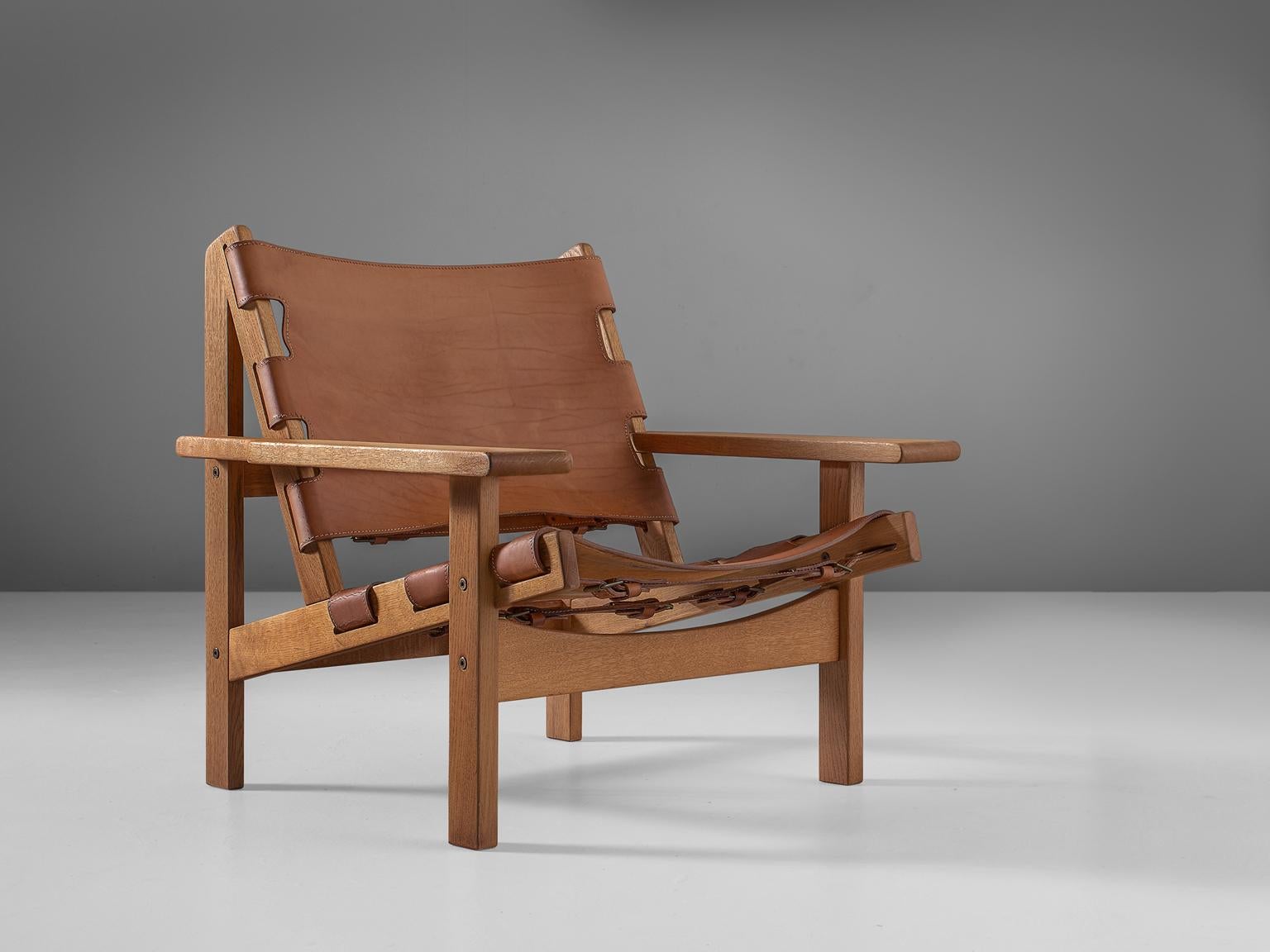 Erling Jessen, lounge chair model 168, oak and leather, Denmark 1960s. 

Stunning 'Jagt Stolen' by Erling Jessen, who was inspired by Børge Mogensens Spanish Chair. The frame consists of solid oak and makes a sturdy appearance. The oblique place