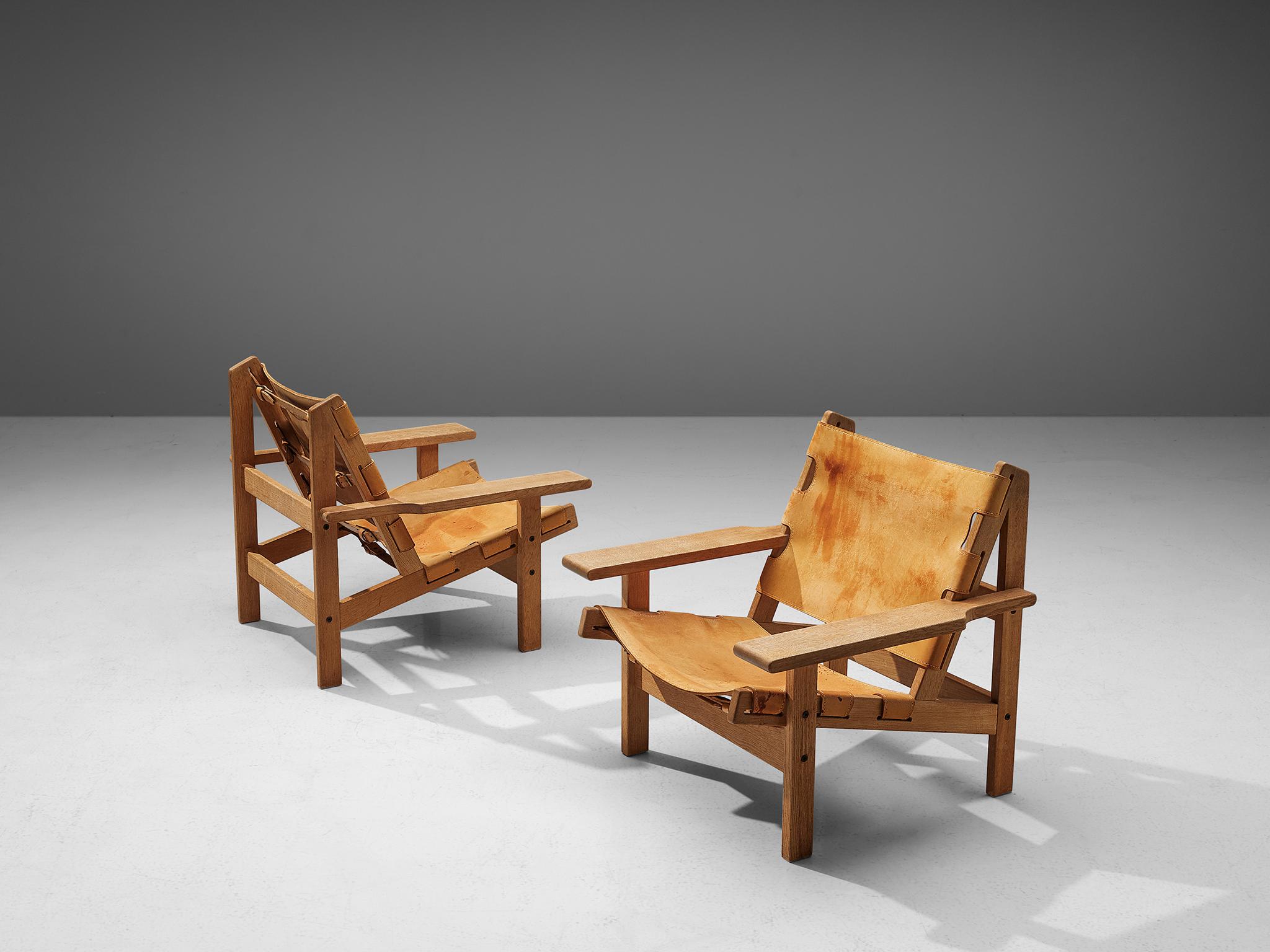 Erling Jessen, pair of lounge chairs model 168, solid oak, leather, Denmark, 1960s.

This set shows exquisite Danish craftsmanship and aesthetics. The set features traits of its hunting- and a cabin lodge-style thanks to its strong, sturdy