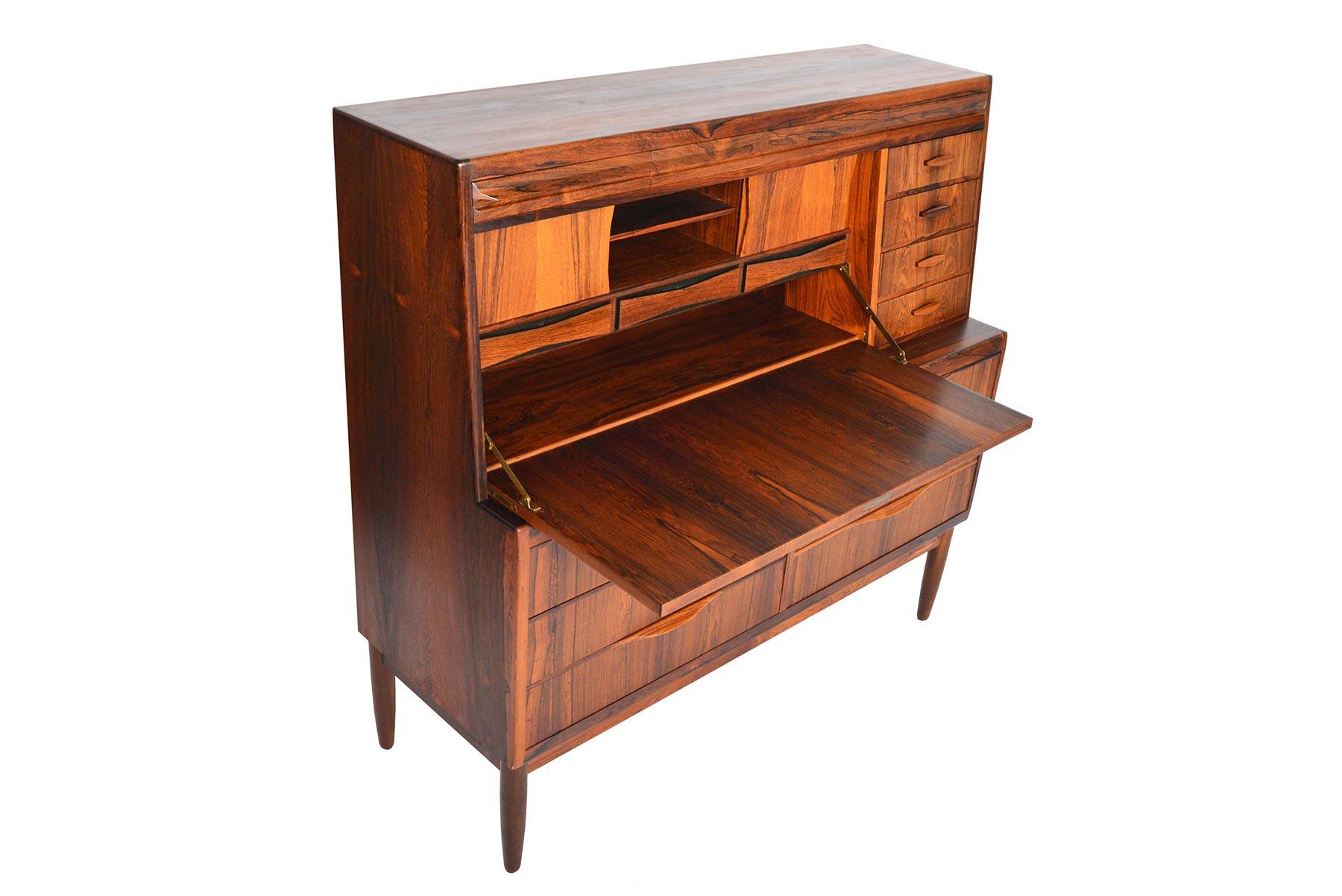 Designed by Erling Torvits for Klim Møbelfabrik in the 1960s, this rare and incredible Danish modern secretary desk is crafted from Brazilian rosewood. Top desk surface folds down to reveal three bow tie drawers, which sit below two sliding door