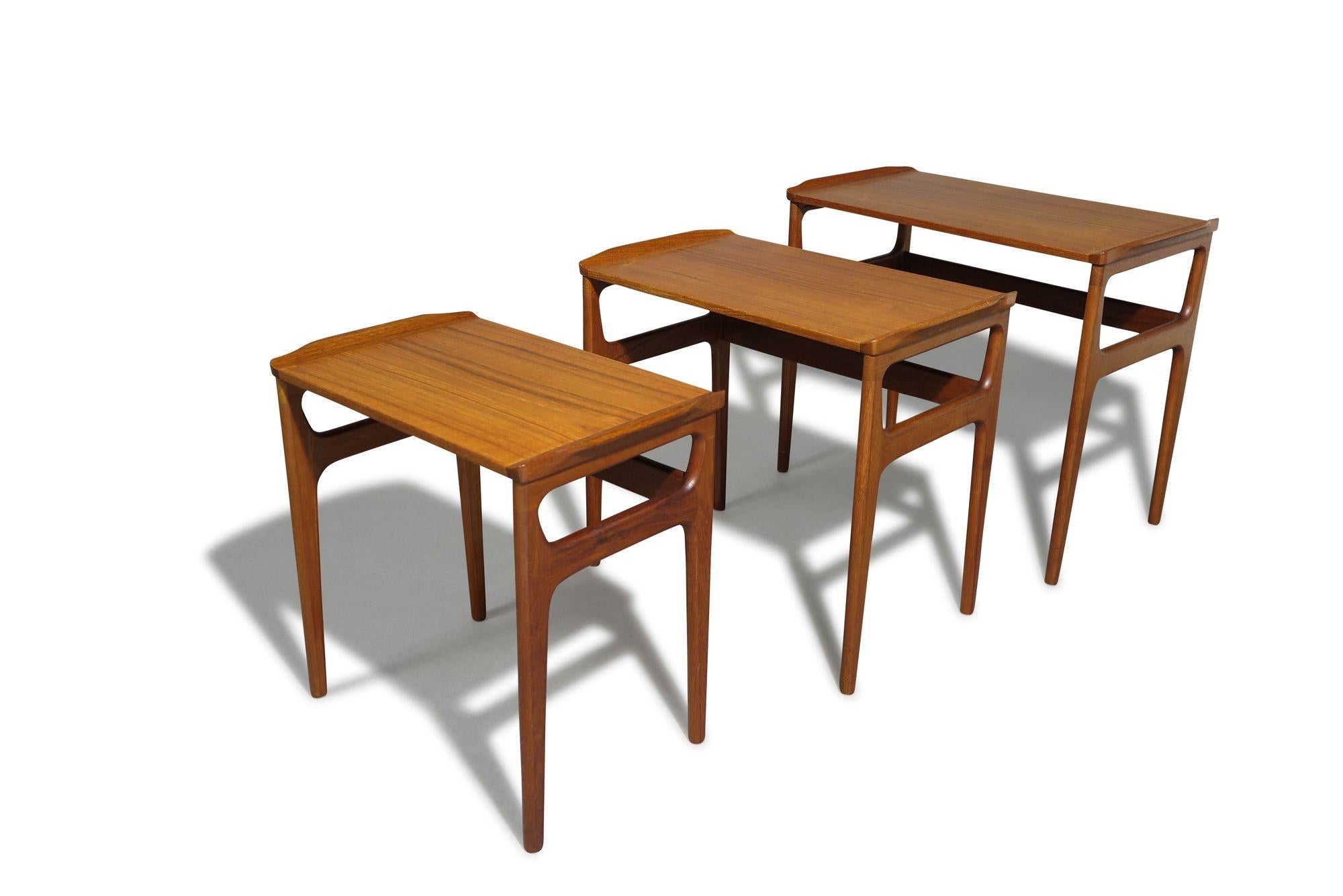 A set of three teak nesting tables designed by Erling Torvits, Denmark. Crafted with book-matched teak surfaces atop solid teak tapered legs. Finely restored with a hand-rubbed natural oil finish, they are in excellent condition, showing only minor