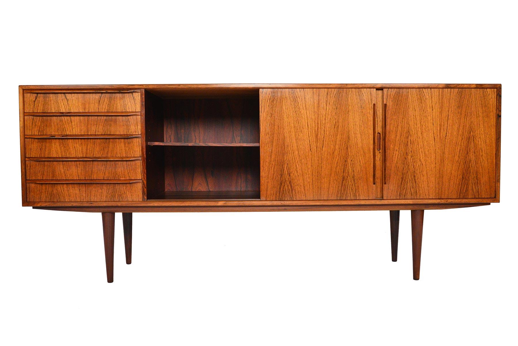 This striking Danish modern rosewood credenza was designed as Model 26 by Erling Torvits for Knud Nielsen in the 1960s. Crafted in beautifully sun bleached rosewood, this piece features a bank of five-drawers and two-bays with adjustable shelves.