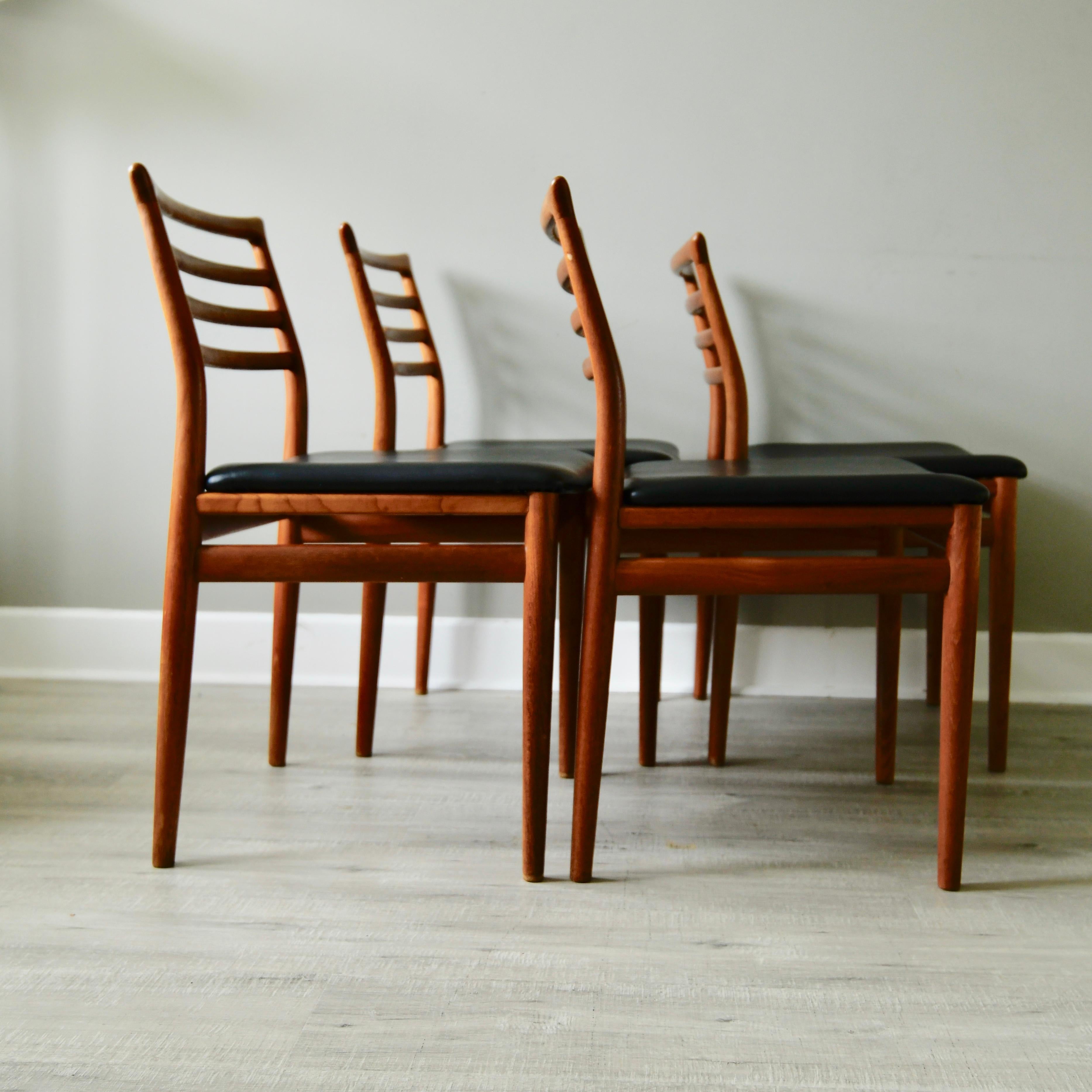 Set of four teak Scandinavian dining chairs with original black leatherette seats by Erling Torvits for Soro Stolefabrik from the 1970s.