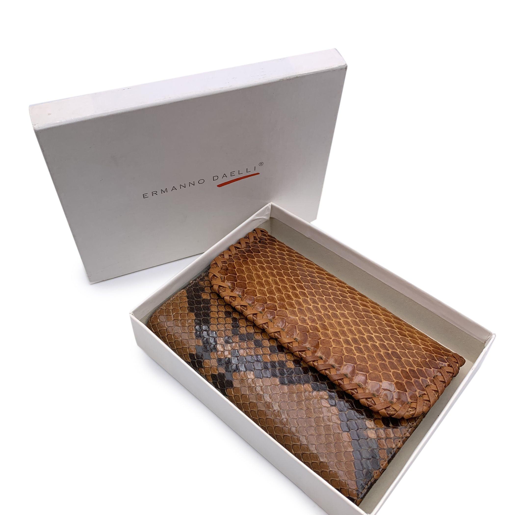 Ermanno Daelli flap wallet. Made of light brown glossy leather.Flap with button closure. Inside it has 1 bill compartment, 1 zip compartment for coins, 2 open pockets, 3 credit card slots and 1 checkbook holder 'Ermanno Daelli' signature engraved