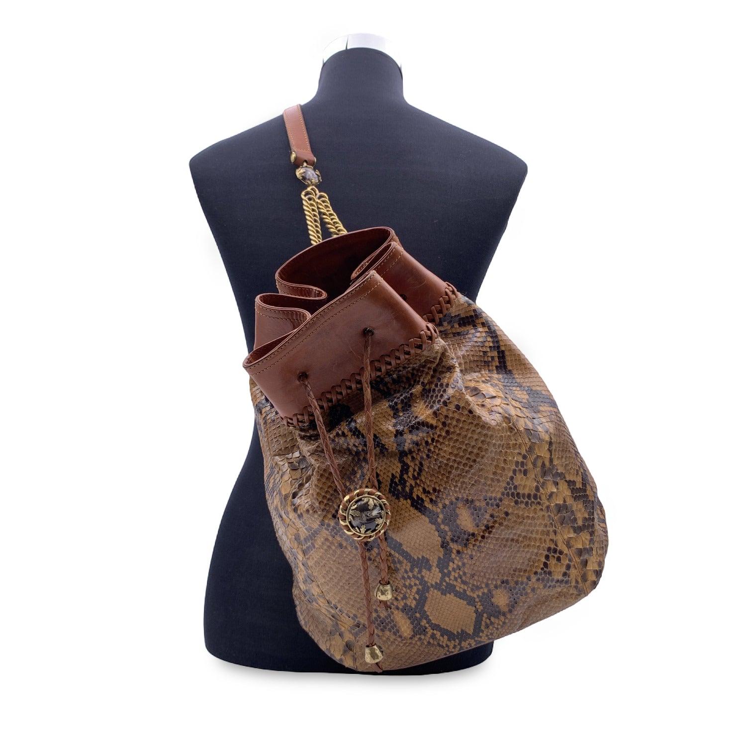 Vintage Ermanno Daelli drawstring bucket in brown leather. Drawstring closure on top. Single shoulder strap in leather with gold metal chain. Fabric lining. 1 side zip pocket inside. 'Ermanno Daelli' signature inside . Details MATERIAL: Leather