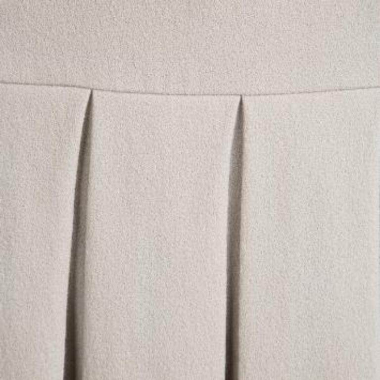 Make a statement with this effortless and versatile style from Ermanno Scervino. The beige colored mini skirt has a broad band with darts for great fit. Box pleats make this a playful separate. Be winter ready with the woolen blend skirt, pair it