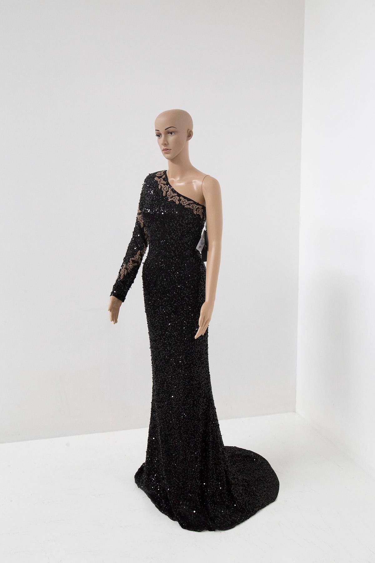 In the dimly lit room, she stood poised and elegant, a vision of timeless beauty. Her one-shoulder black evening gown, adorned with intricate black sequin embellishments, glistened like a thousand stars against the night sky. Each sequin had been