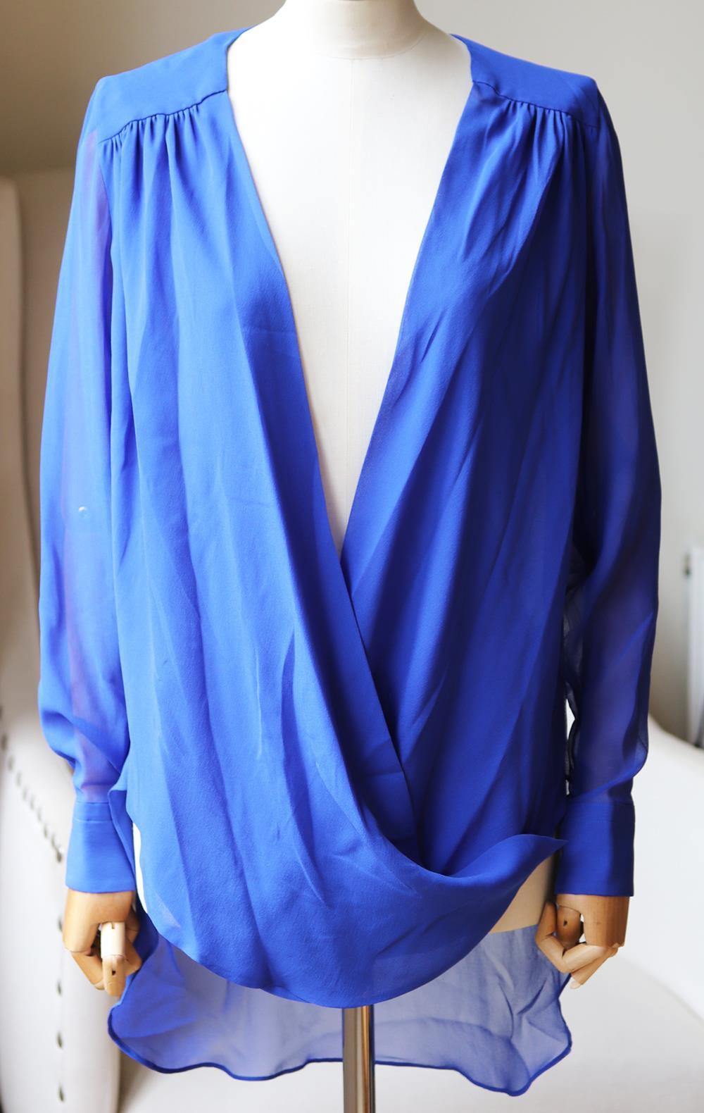 Cut to fall fluidly over the body, this semi-sheer silk shirt has an effortlessly draped collar. 
Blue silk. 
Push button fastening along side. 
100% Silk.

Size: IT 38 (UK 6, US 2, FR 34)

Condition: No sign of wear