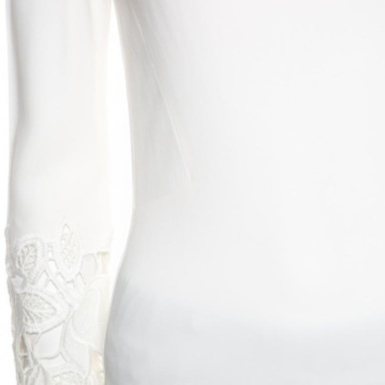 Nos encanta este top blanco roto de Ermanno Scervino por su gran estilo y atractivo. Presenta mangas largas, cuello redondo y adornos florales de encaje. Puedes combinarlo con pantalones o faldas y tacones altos.