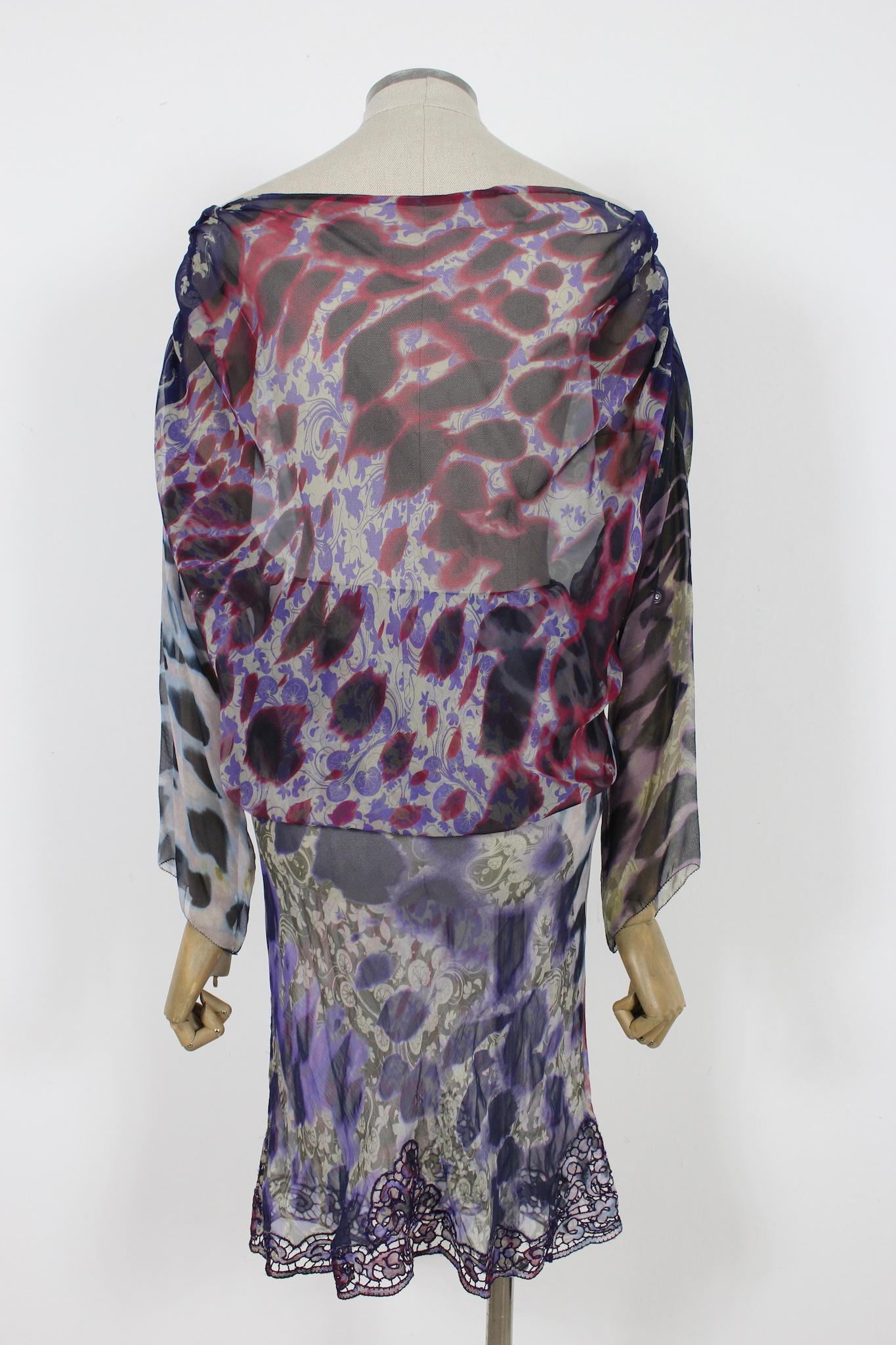 Cette robe de soirée Ermanno Scervino est confectionnée en soie douce et présente un superbe imprimé floral violet et rouge. La robe présente une silhouette évasée et une taille élastique, offrant une coupe confortable et flatteuse. L'ourlet de la