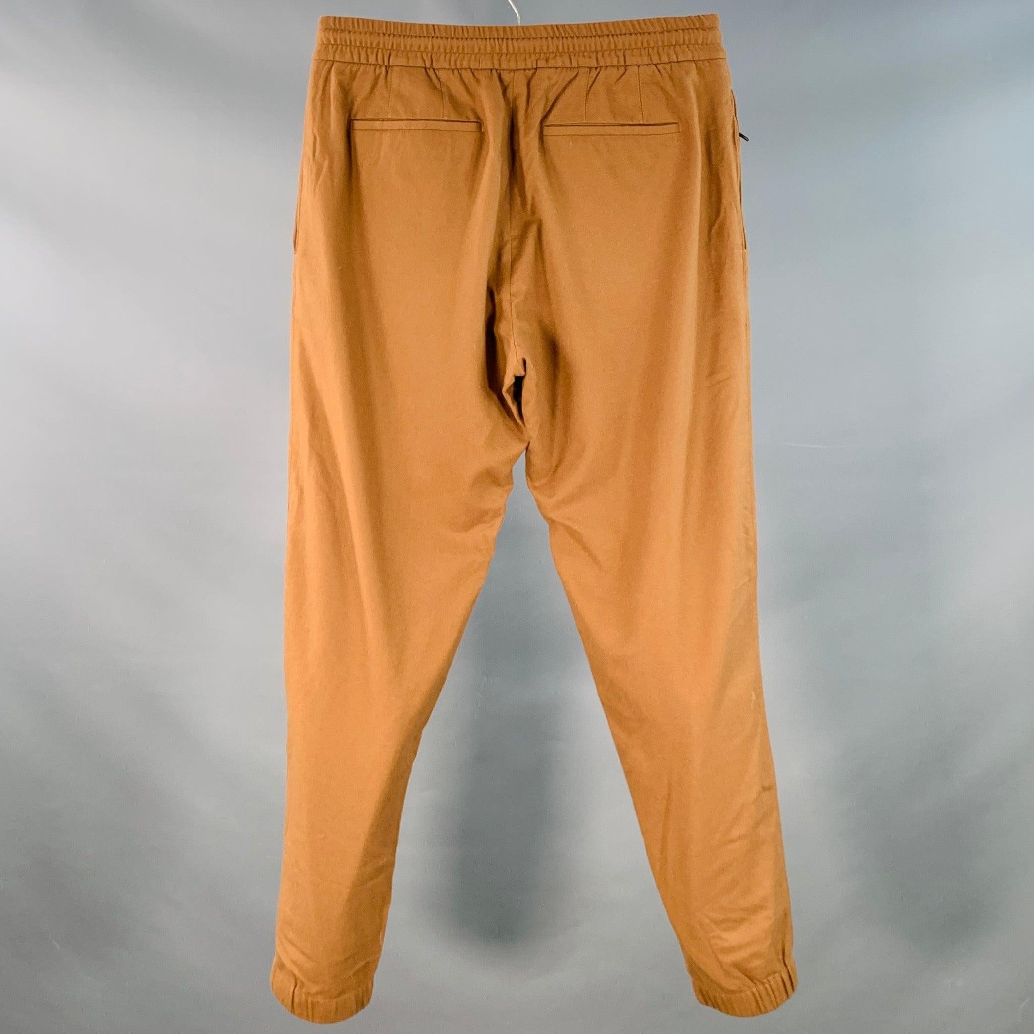 Pantalon décontracté ERMENEGILDO Zegna en sergé mélangé de laine et de cachemire brun tabac, doté d'une jambe fuselée avec poignets élastiques, de quatre poches (deux poches plaquées, deux poches passepoilées) et d'une fermeture à glissière avec