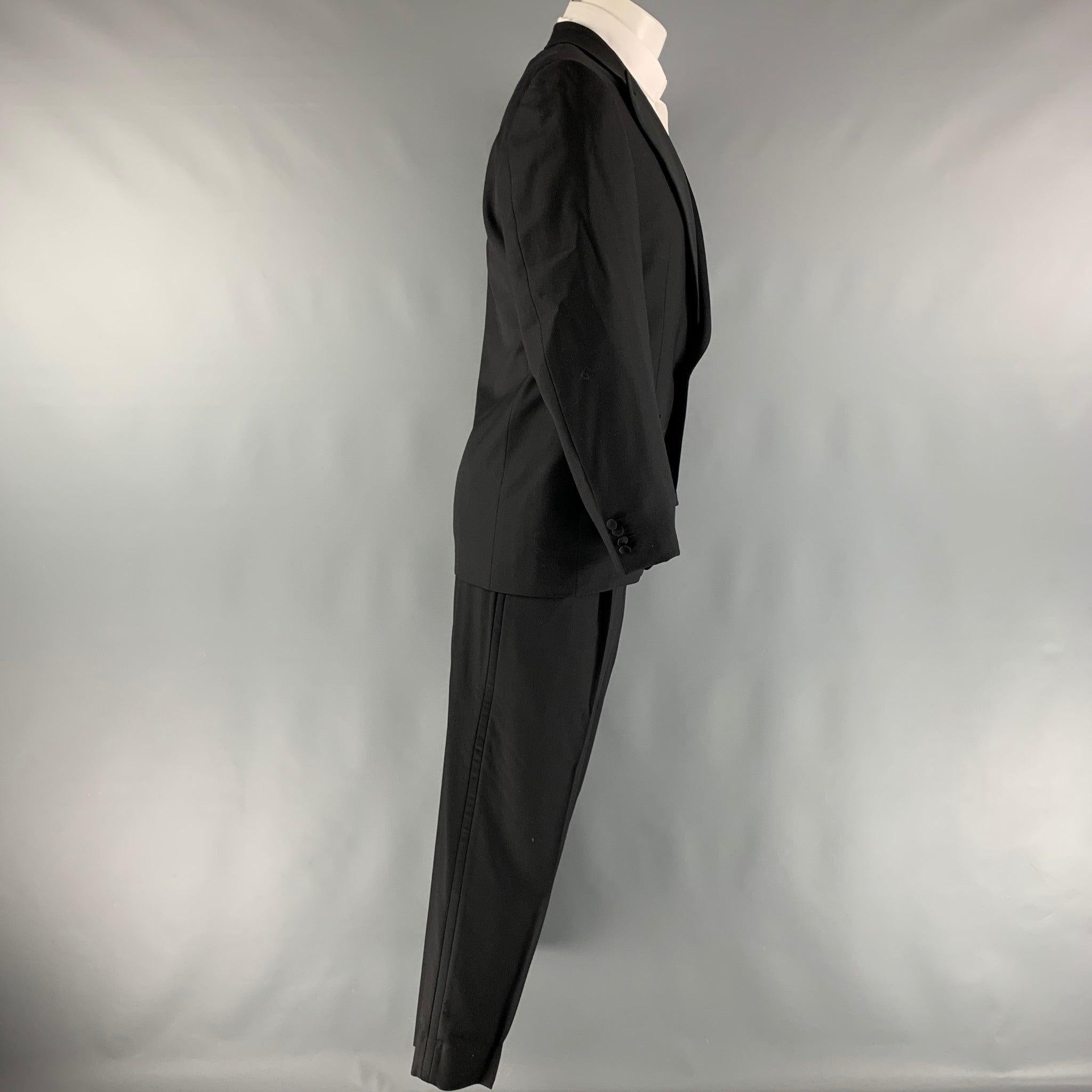 ERMENEGILDO ZEGNA for Neiman Marcus tuxedo comes in a black wool with a full liner and includes a single breasted, single button sport coat with a peak lapel and matching pleated front trousers. Made in Switzerland.Excellent Pre-Owned Condition.