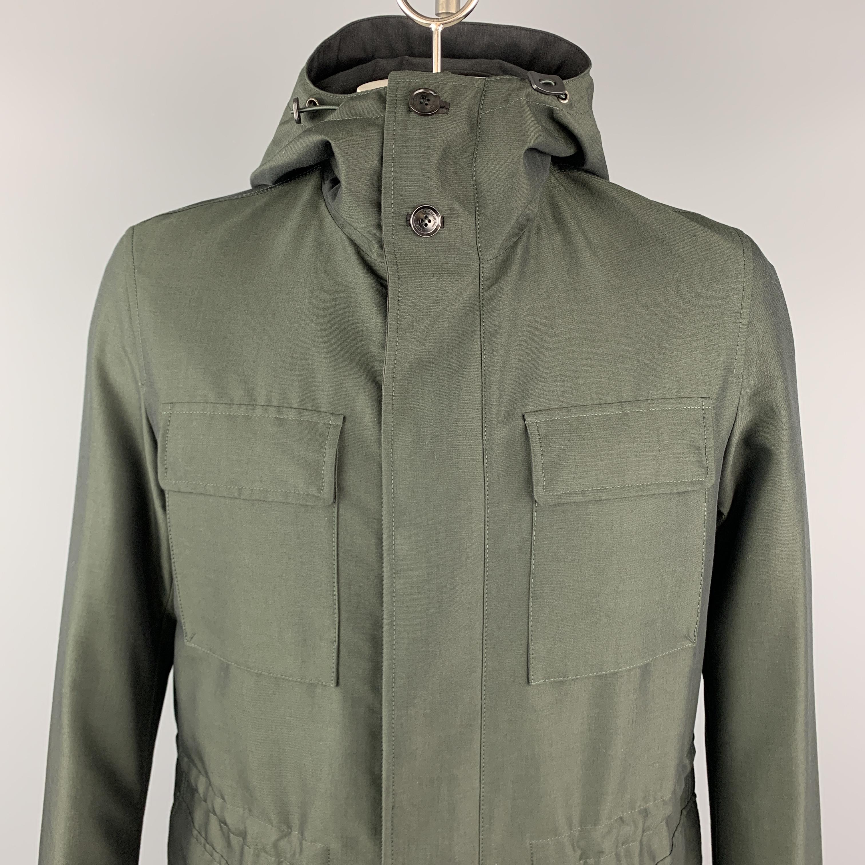 ERMENEGILDO ZEGNA anorak style coat comes in olive green wol cotton blend sharkskin with a high collar hood, zip front with hidden snap placket, drawstring waist, patch flap pockets, and brown suede trim. Made in Italy.

New with Tags.
Marked: IT