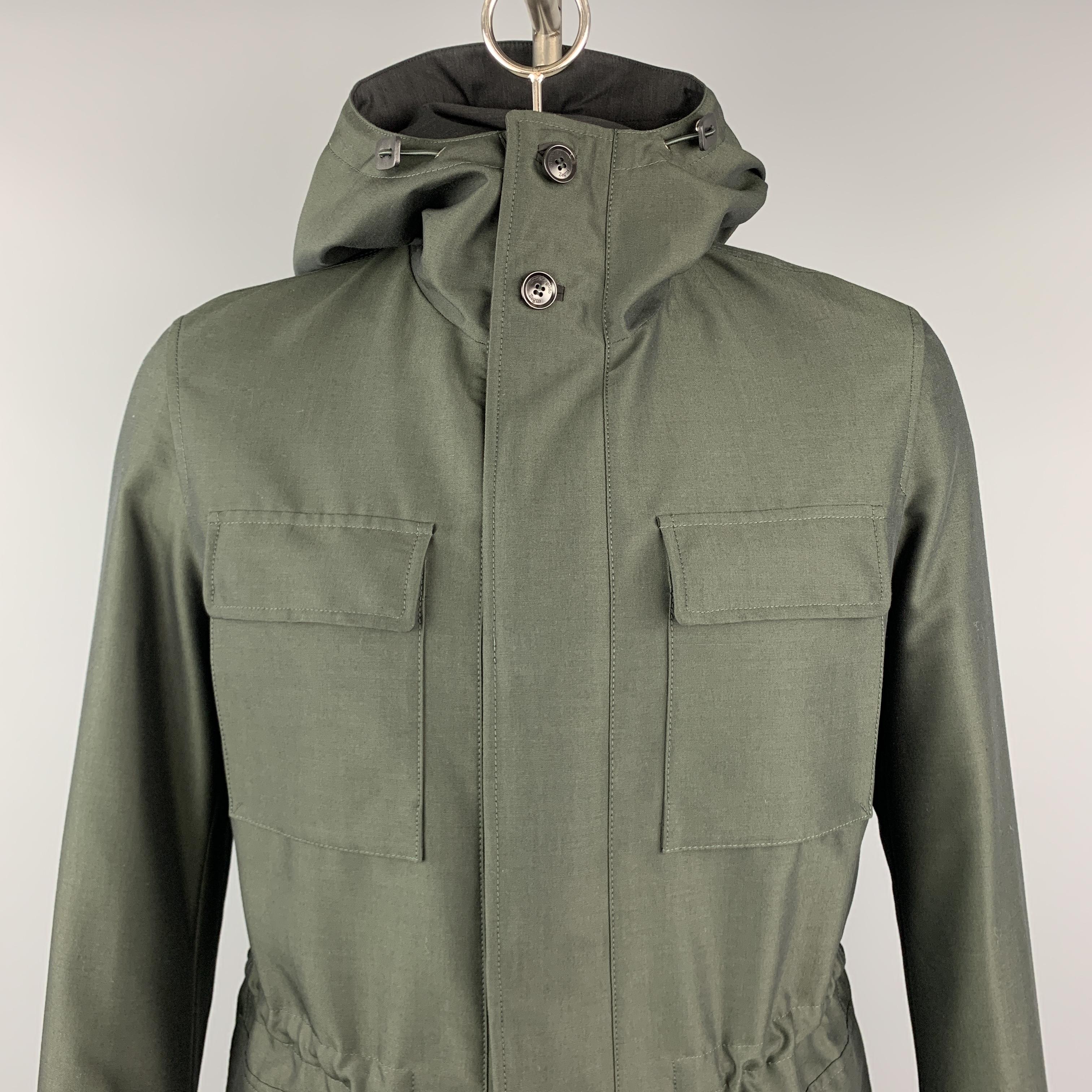 ERMENEGILDO ZEGNA anorak style coat comes in olive green wol cotton blend sharkskin with a high collar hood, zip front with hidden snap placket, drawstring waist, patch flap pockets, and brown suede trim. Made in Italy.

New with Tags.
Marked: IT