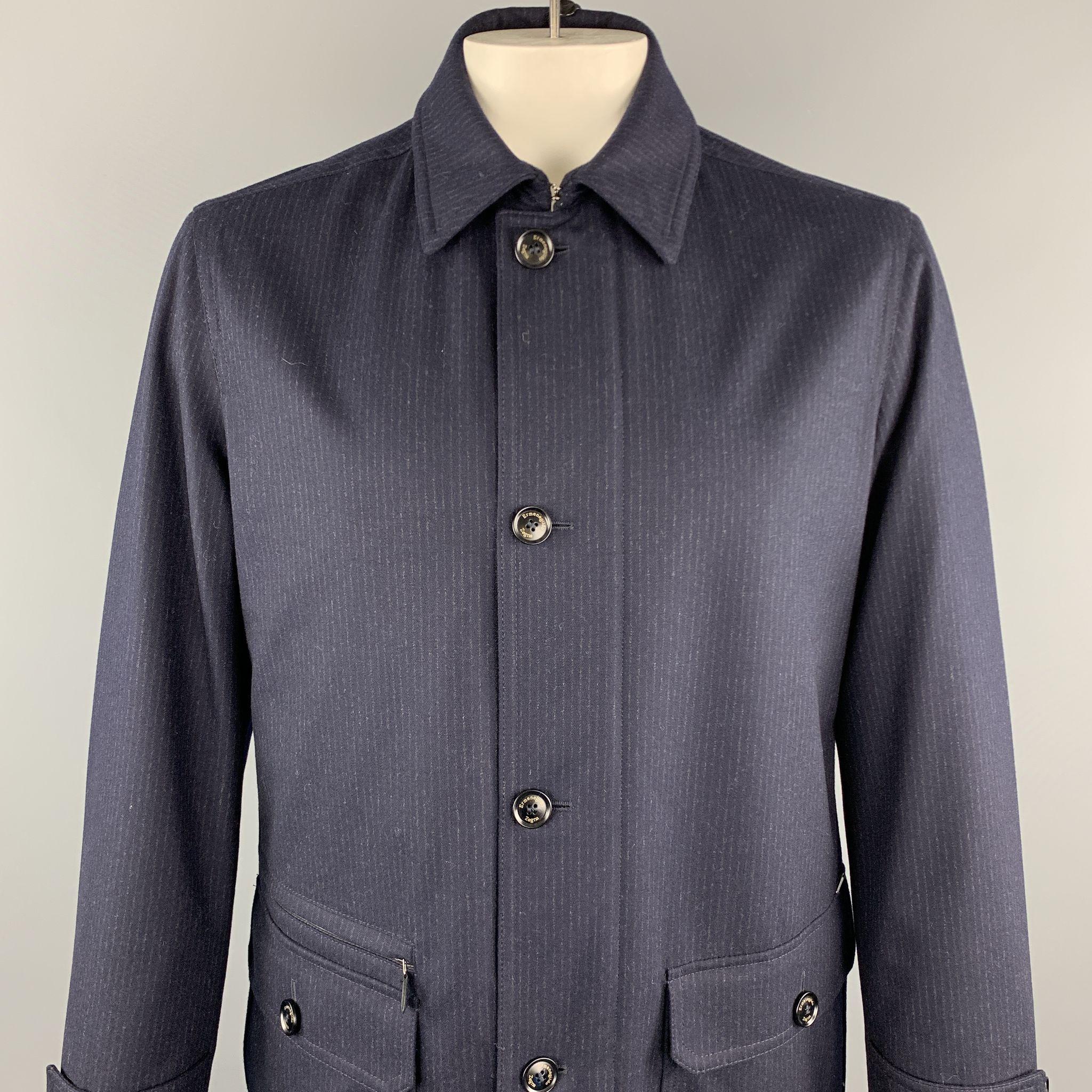 Retail Price - $2,300.00

ERMENEGILDO ZEGNA Coat comes in navy pinstripe wool featuring patch pockets, zipper pockets, and a zipper & buttoned closure. 

New With Tags.
Marked: 52

Measurements:

Shoulder: 17.5 in. 
Chest: 42 in. 
Sleeve: 24.5 in.