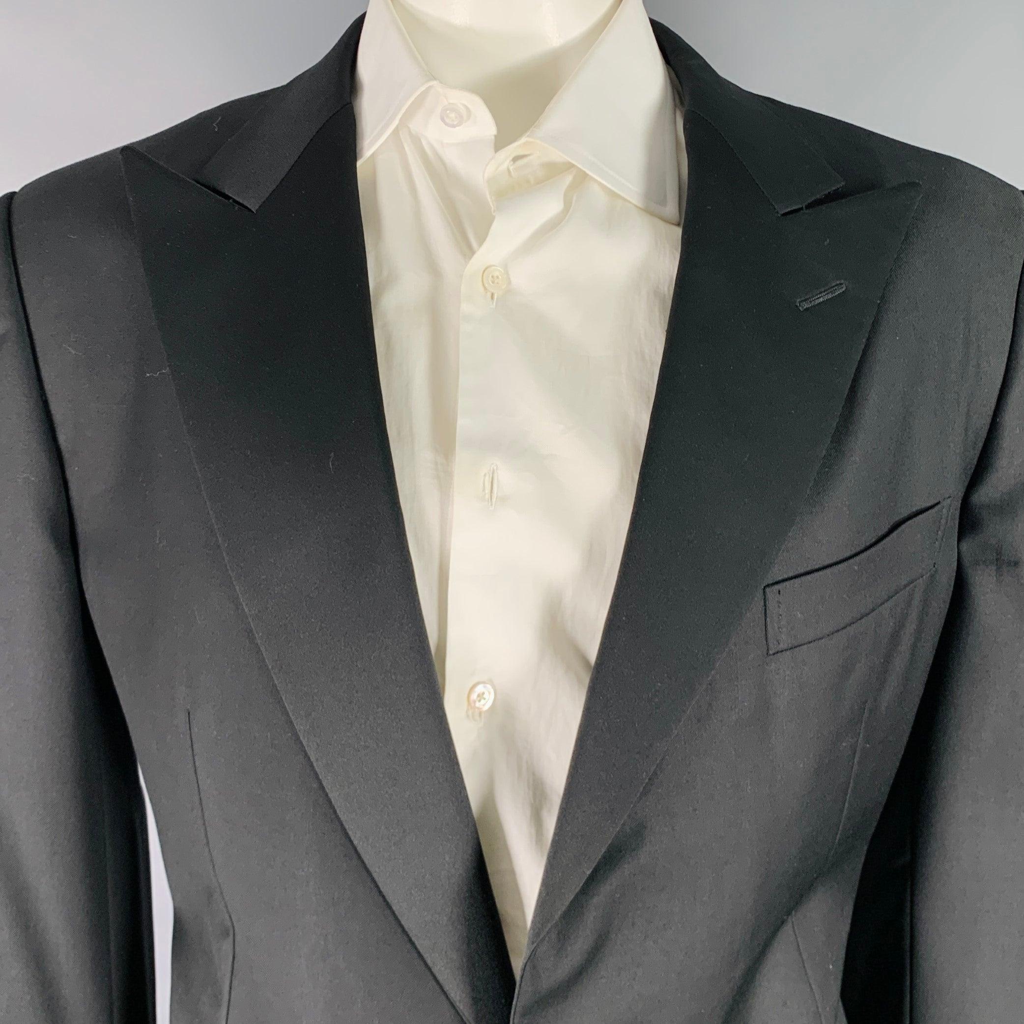 Smoking Ermenegildo Zegna
in lana nera con fodera integrale e comprende un cappotto sportivo monopetto a un bottone con bavero a punta e pantaloni a pieghe abbinati. Prodotto in Svizzera. Nota: le maniche sono leggermente irregolari, si prega di