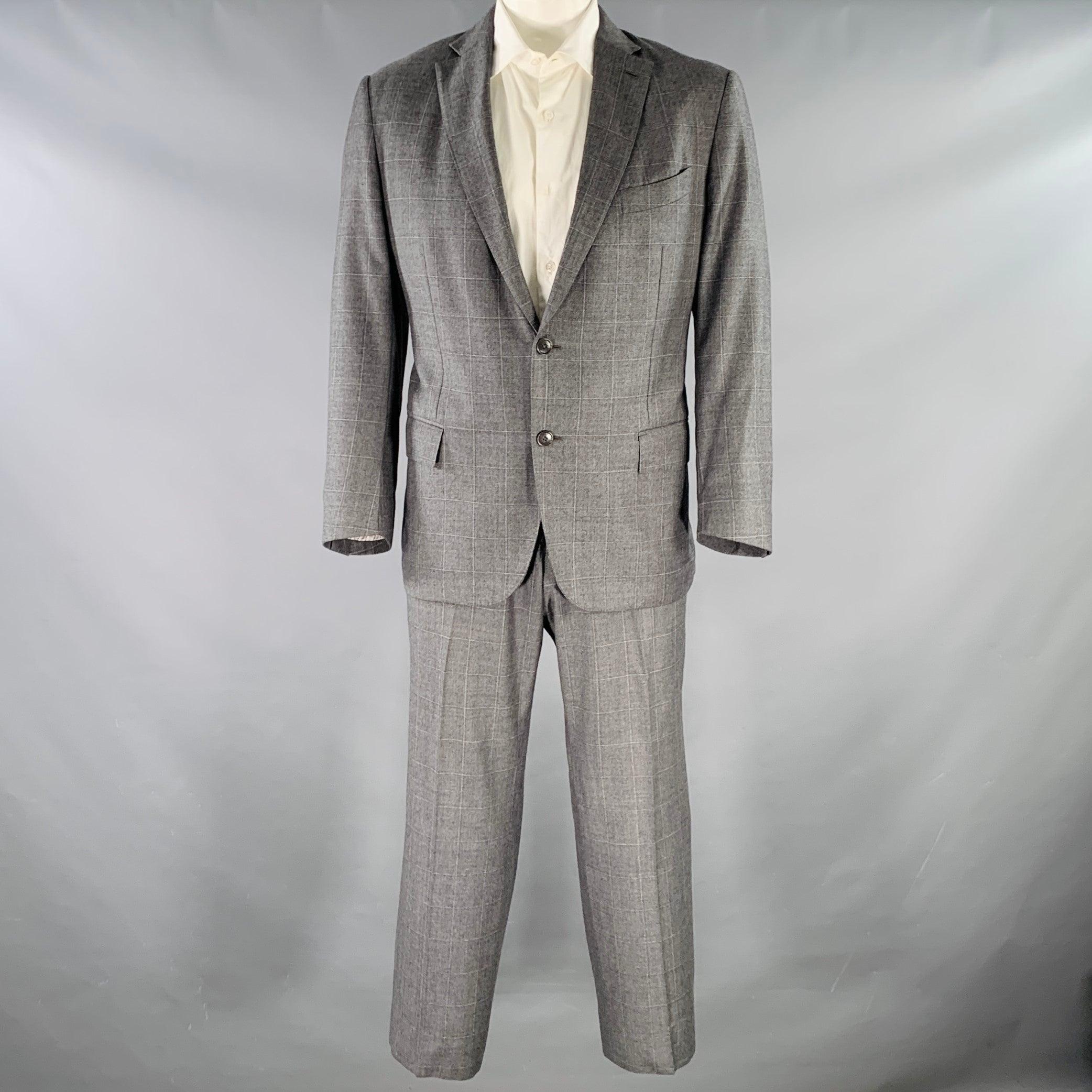 ERMENEGILDO ZEGNA Costume
en laine à carreaux gris et blancs avec une doublure complète et comprend un manteau de sport à double boutonnage à revers échancré et un pantalon assorti à devant plat. Fabriqué en Italie. Très bon état. Signes mineurs