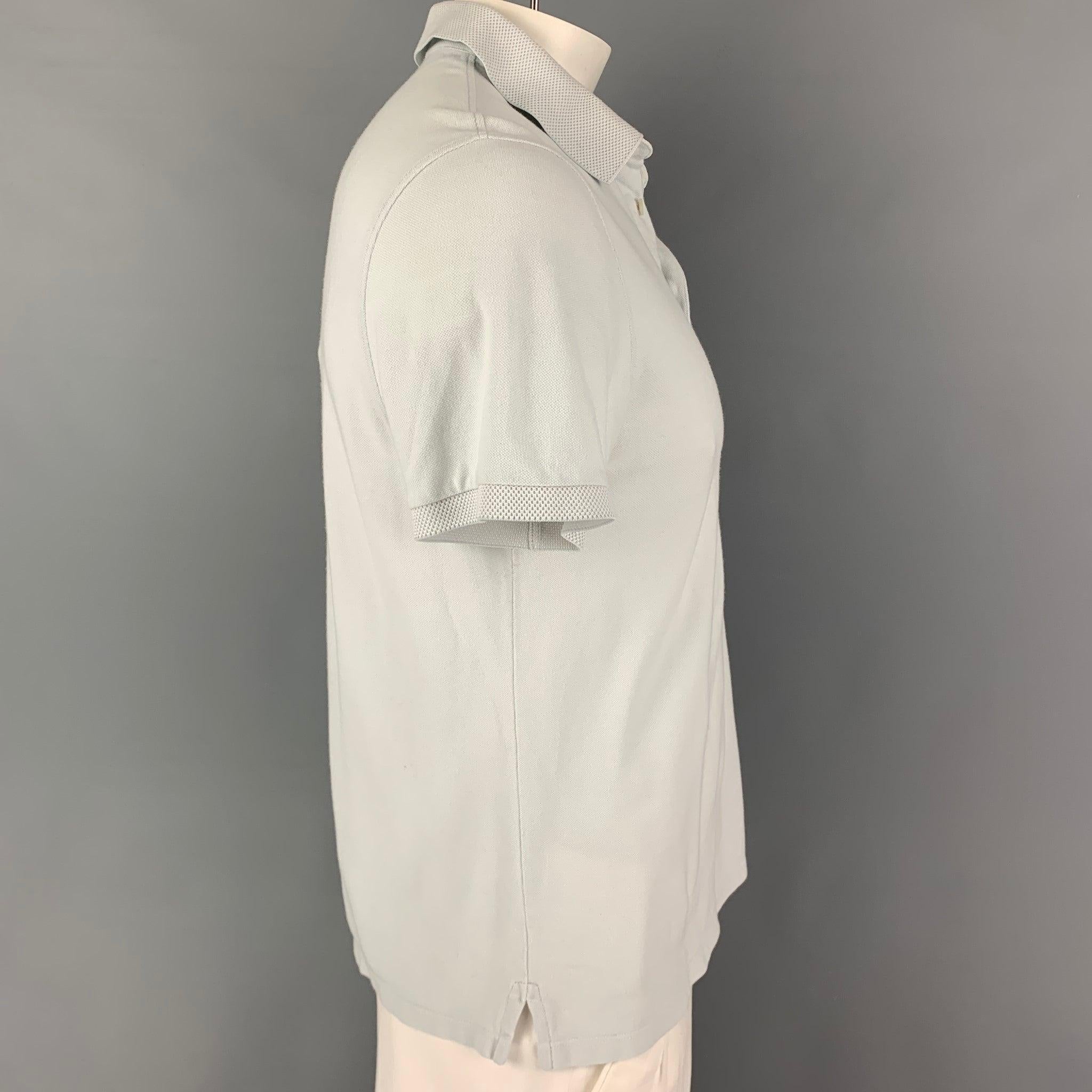 ERMENEGILDO ZEGNA polo comes in a light blue cotton featuring short sleeves, spread collar, and a half button up closure.
Good
Pre-Owned Condition. Light wear & minor hole ar back. As-is.  

Marked:   M/50 

Measurements: 
 
Shoulder: 18.5 inches