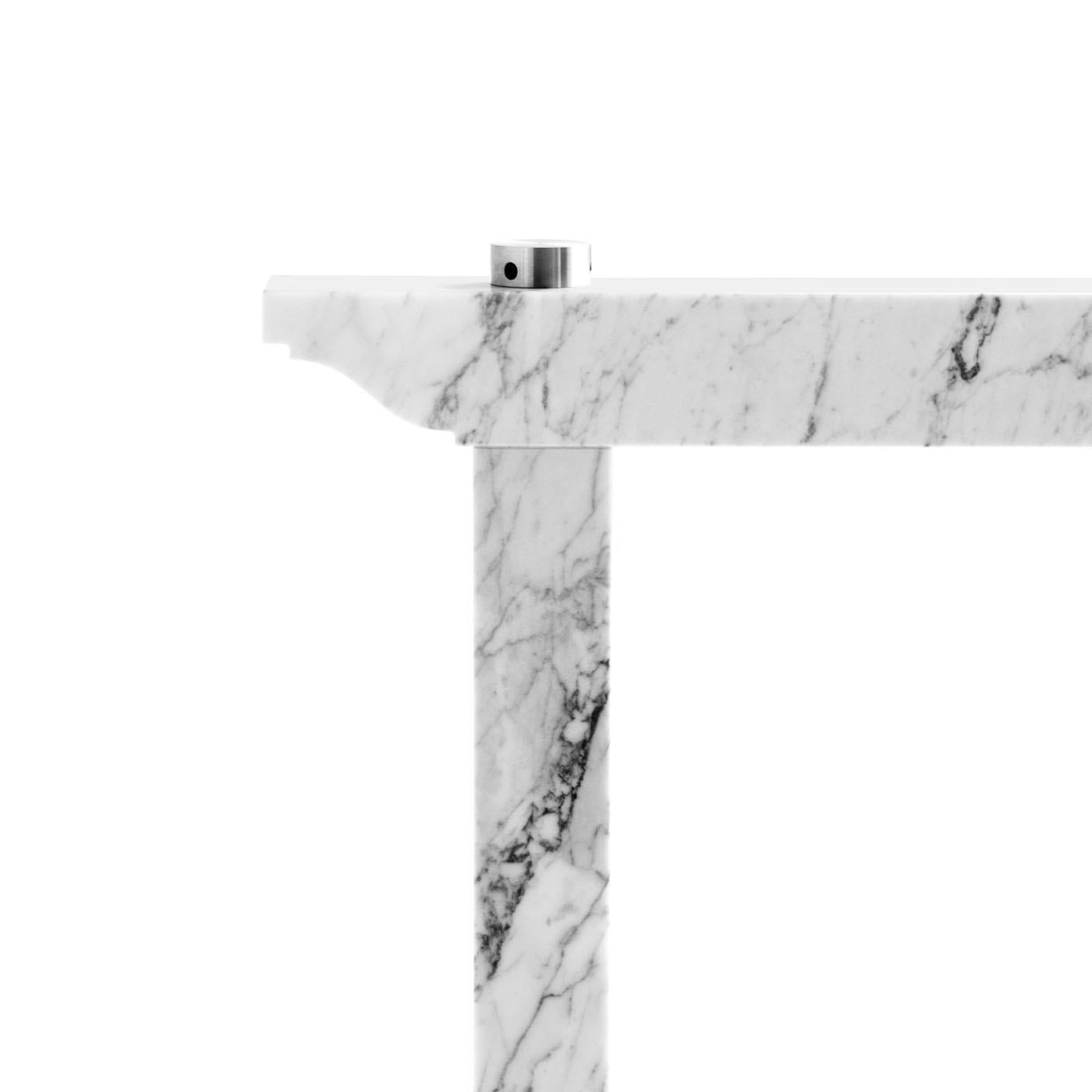 This Carrara white marble trestle, designed by Enrico Tonucci, is made to support tops in glass, wood, marble or other materials. Its lines, rigorous and squared, design an upside-down U letter. The only whim is a decoration on the sides that evokes