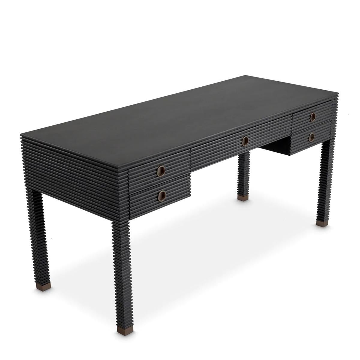 Scrivania Ermos con struttura in rovere massiccio impiallacciato grigio scuro,
con legno di mogano. Scrivania con 5 cassetti con maniglie ad anello
in finitura bronzo.