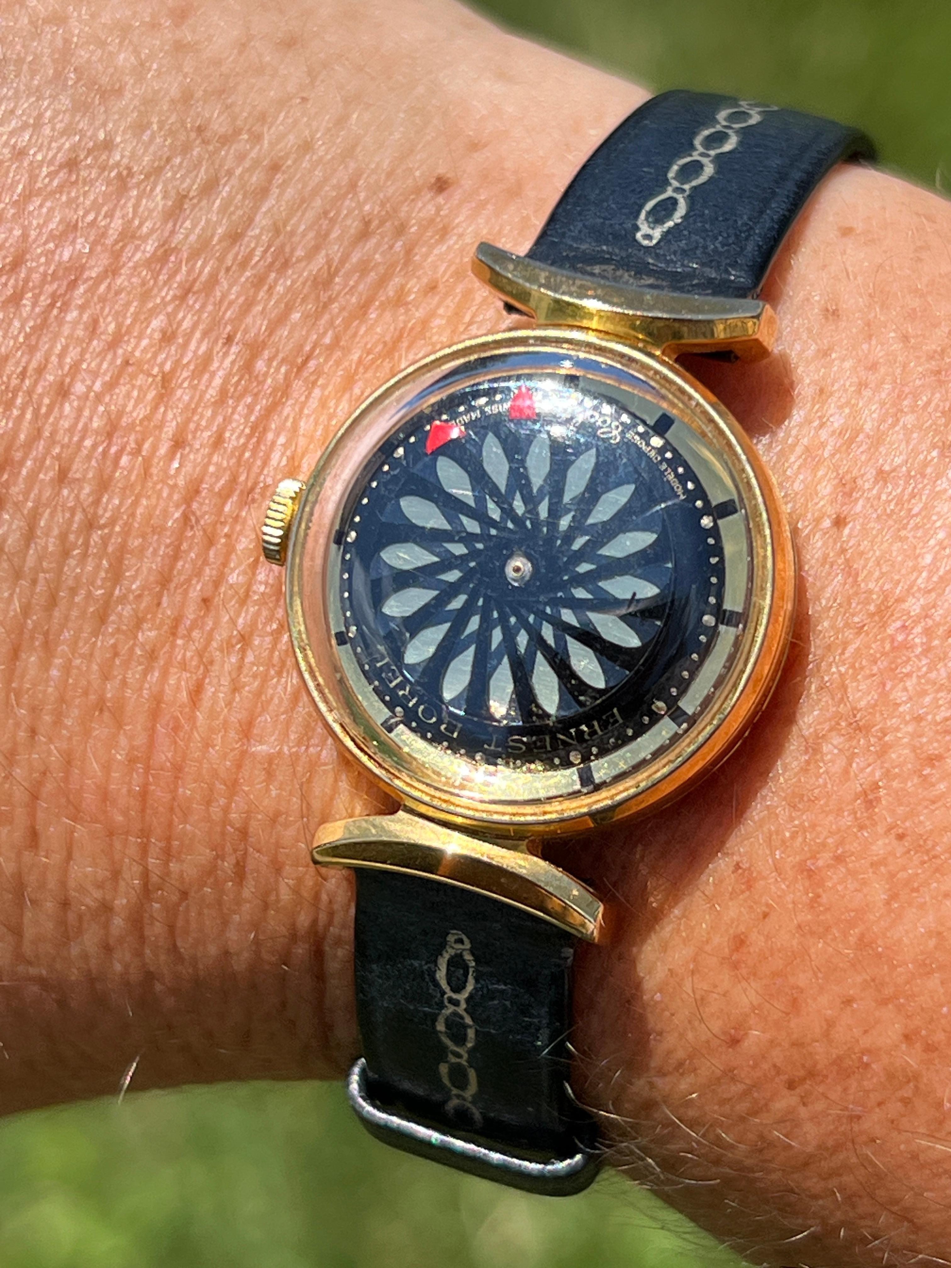 This charming 1960s Ernest Borel Seventeen 17Jewels 26mm Swiss kaleidoscope cocktail watch is a unique and playful timepiece. The watch is gold filled and includes interchangeable 6.5-inch black and white leather bands, allowing for versatile