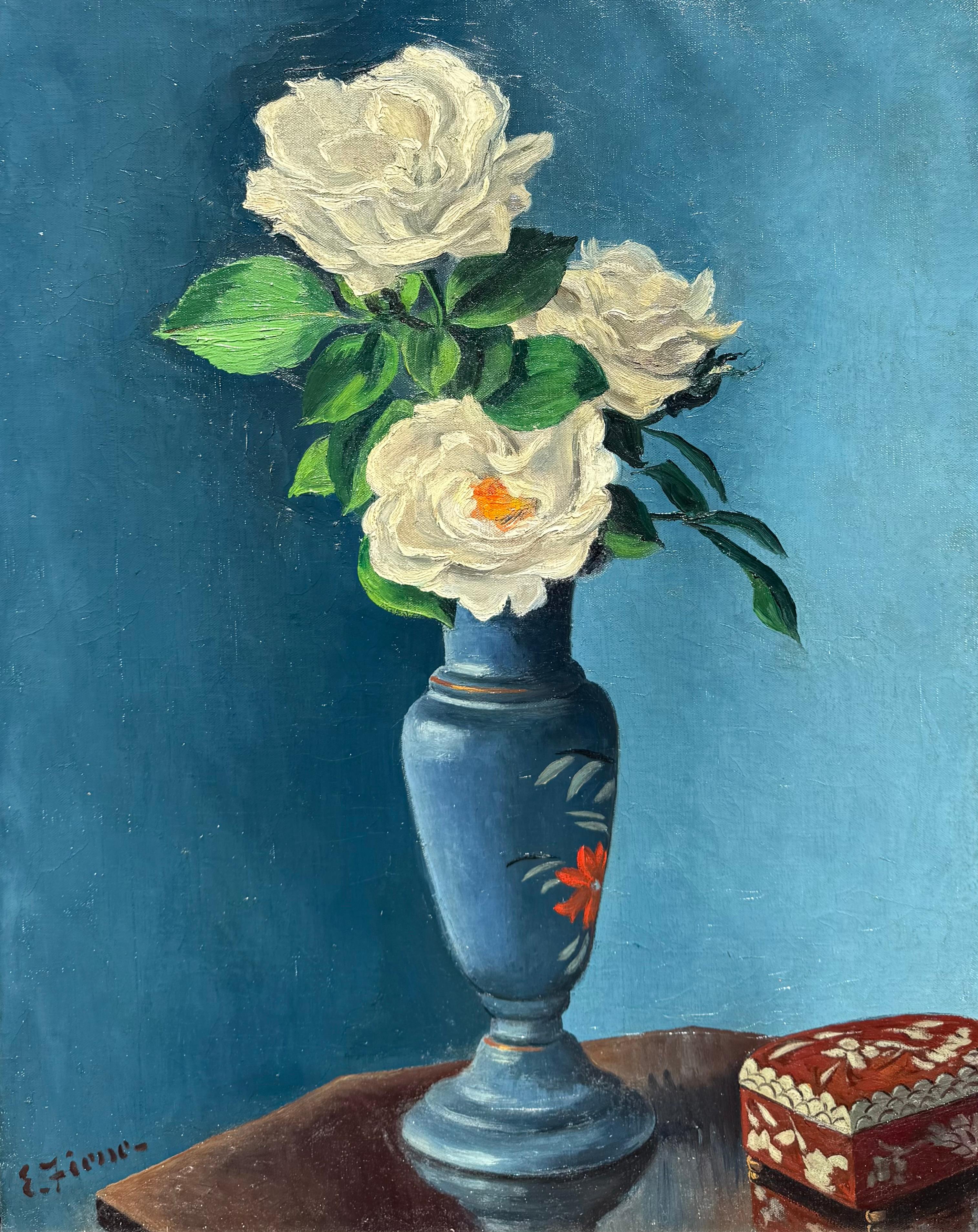 Original oil on canvas painting of white roses in a blue vase by the well known American artist, Ernest Fiene.  Signed lower left by the artist. Titled and signed verso. Condition is very good.  Circa 1935.  The painted is housed in a period faux