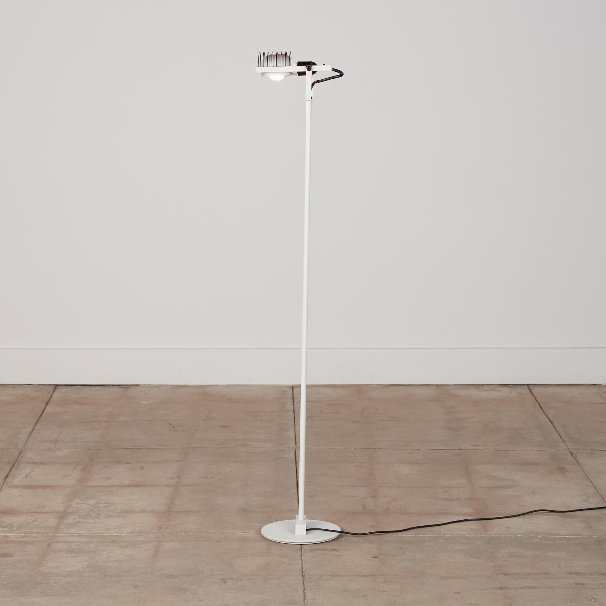 Ernesto Gismondi “Sintesi” floor lamp for Artemide, Italy, c. 1970s. The lamp features a white lacquered metal base and stem with black metal cage detail surrounding the housing for the bulb. The head of the lamp is adjustable and it features the