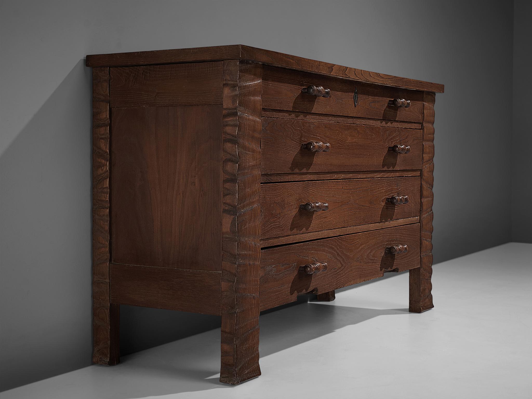 Ernesto Valabrega, chest of drawers, stained oak, brass, glass, Italy, ca. 1935

Chest of drawers with mirror on top. Four large, lockable drawers with two rounded handles each structure the front of the cabinet. The corners are decorated with