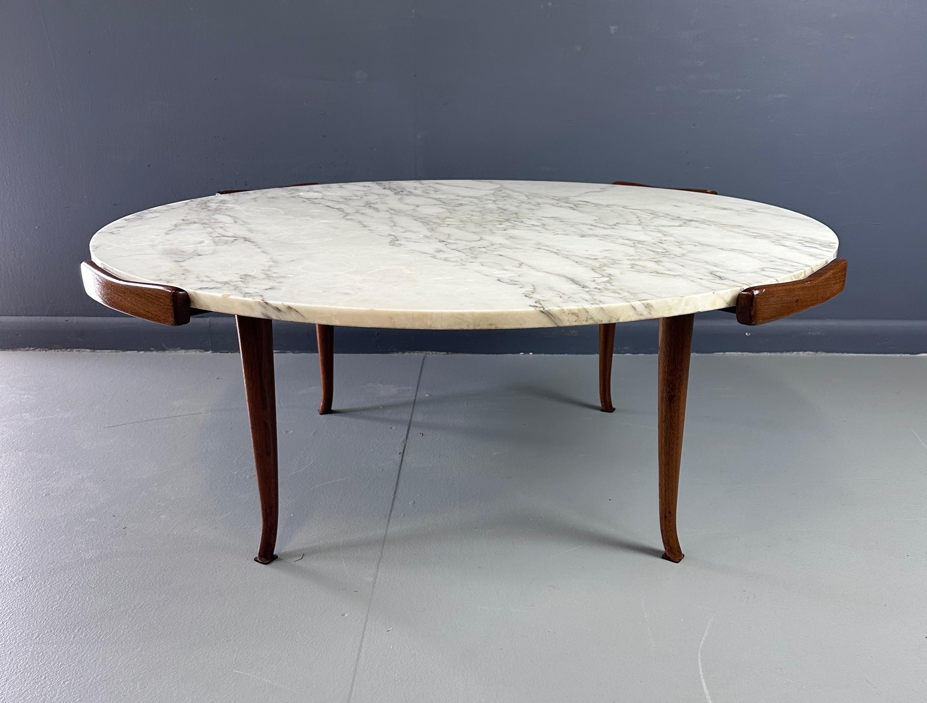 Made in Italy for Fabry Associates. This table has a marble top with framed between four pieces of curved walnut molding cradled atop a solid walnut frame standing on four slender tapered legs with dainty curved toes.