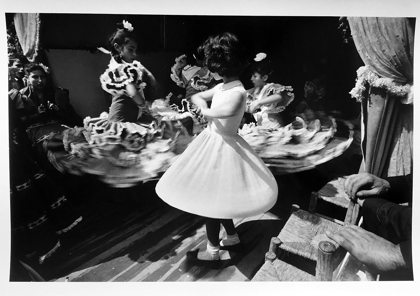 Shot in Seville, Spain, Haas captures a young girl mimicking the movements of flamenco dancers on the dance floor. Dancing Girls, 1956 by Ernst Haas, is an 11” x 14” gelatin silver print. The photograph was printed in 1992 by Chuck Kelton and is