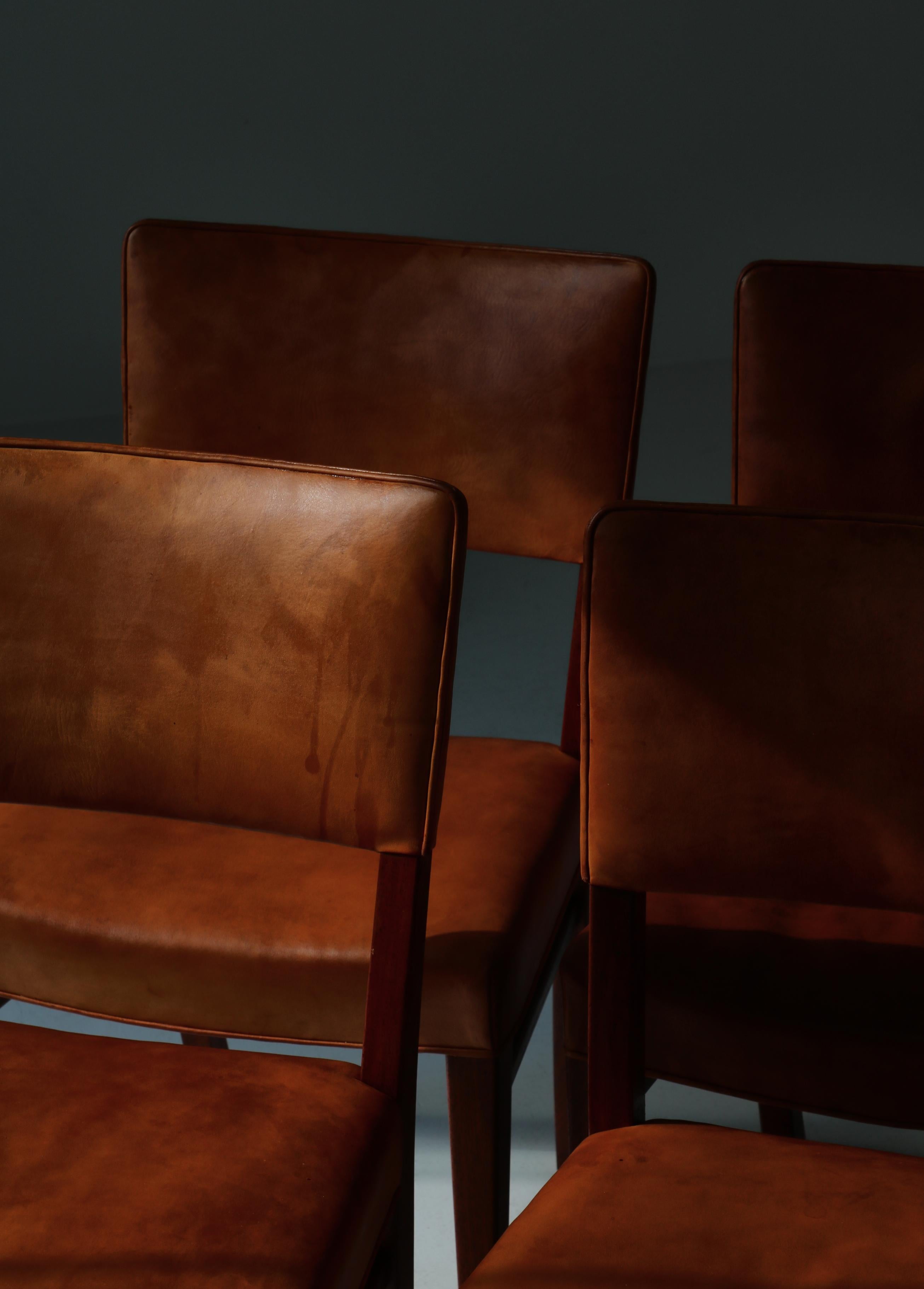 Set of 6 dining chairs by Ernst Kühn made in the 1940s for Lysberg, Hansen & Therp, Copenhagen. Amazingly the chairs all retain the original natural aniline leather that has aged beautifully with a deep and warm patina. Both seats and backs were