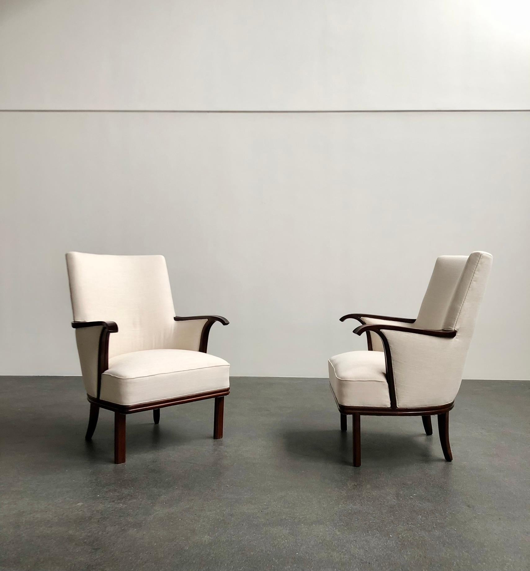 Paire de fauteuils à dossier haut conçus par l'architecte danois Ernst Kühn, 1935.

Nouvellement retapissé en tissu. Le palissandre a été remis à neuf.

Il s'agit d'une paire de chaises unique qui a été fabriquée exclusivement pour l'intérieur de la