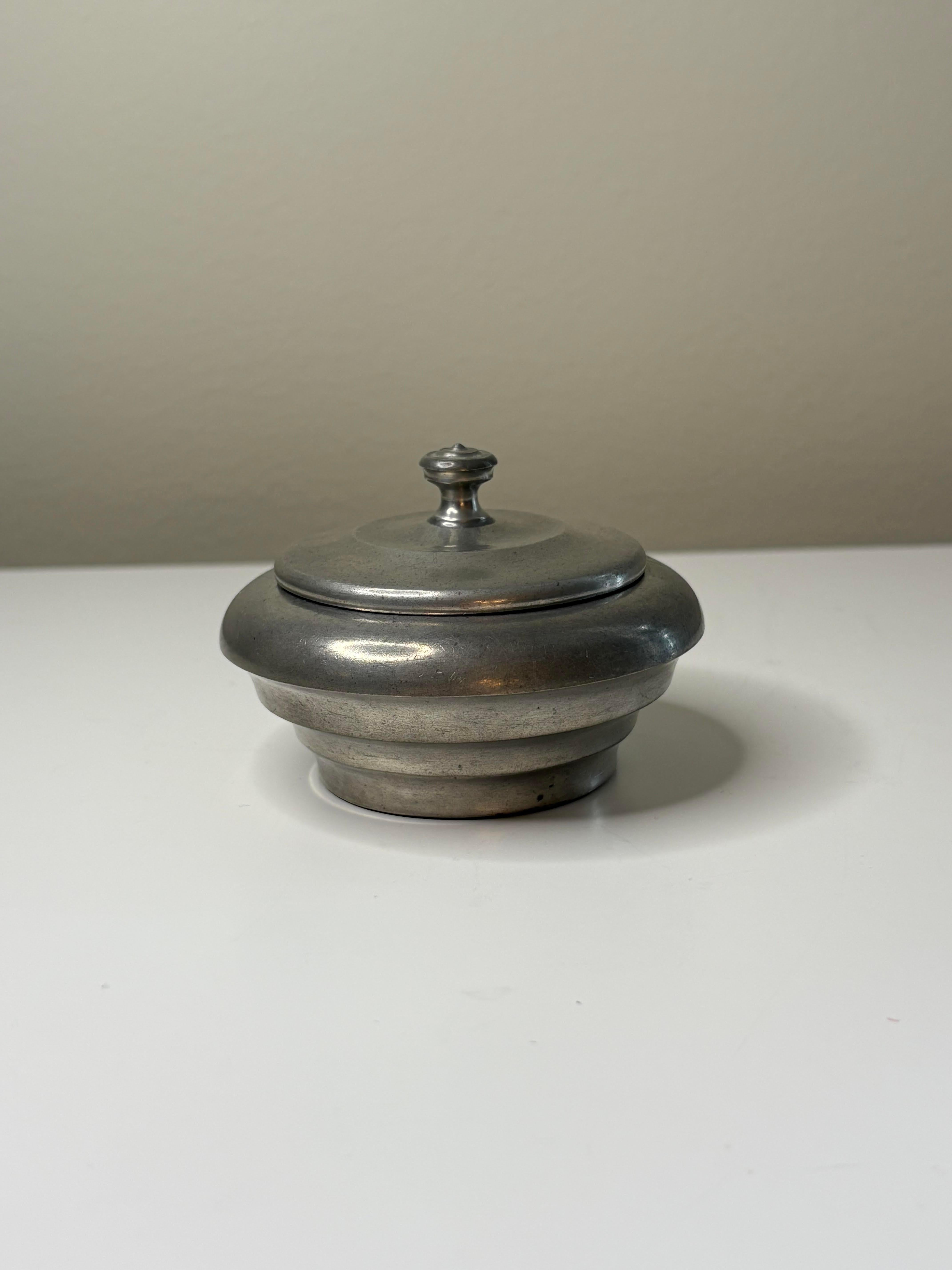 Scatola con coperchio in peltro di Ernst Svedbom, Svezia, datata 1932. Caratterizzato da una forma arrotondata a gradini e da un semplice terminale, il design riflette l'eleganza e la sobrietà del primo modernismo scandinavo. Marcato dal produttore.