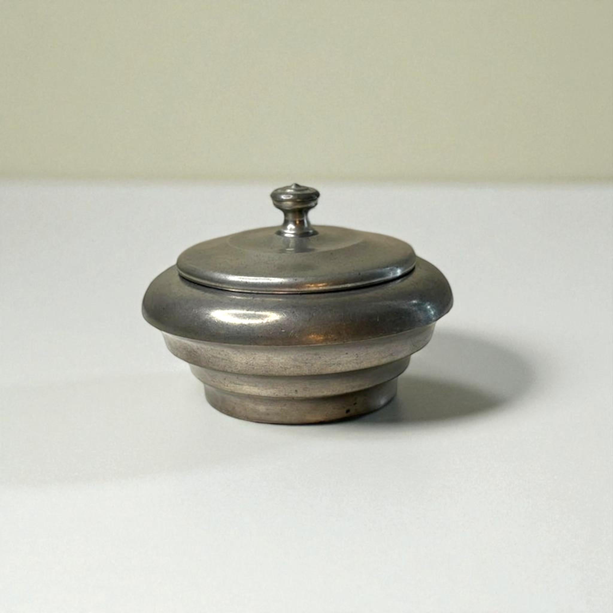 A streamlined pewter lidded box by Ernst Svedbom, Sweden, dated 1932. Featuring a rounded stepped form with a simple finial, the design reflects the elegance and restraint of early Scandinavian modernism. Marked by the maker.