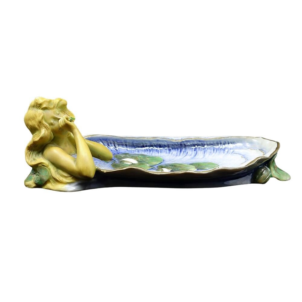 Offering this gorgeous Ernst Wahliss, Art Nouveau, hand-painted, porcelain figural tray. This tray features a nude maiden smelling an applied flower on a blue painted lily pad aquatic designs with flower design. Tray is made in Turn-Wien (Austria)