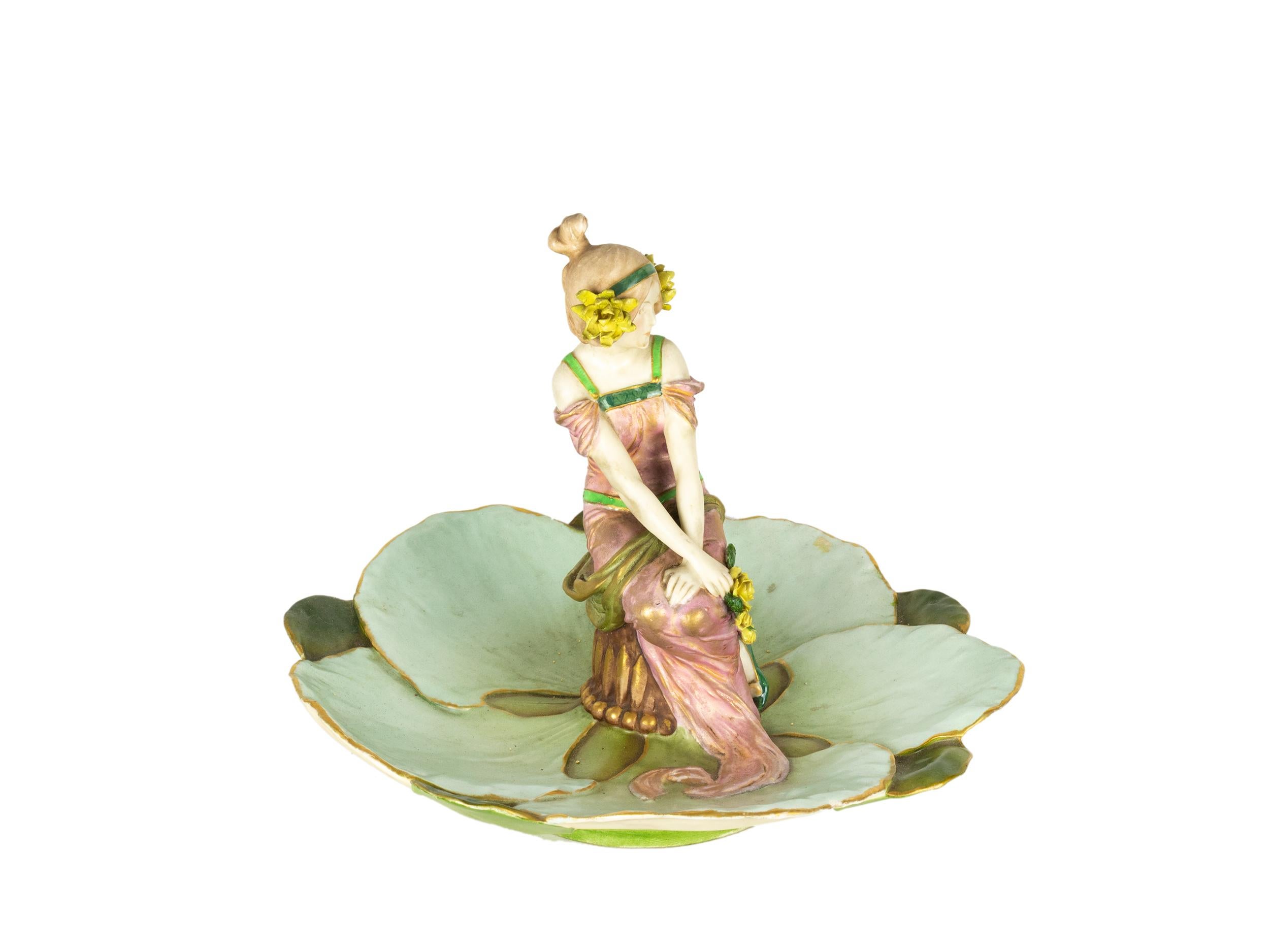 Ein außergewöhnliches, im Stil der Secession von Ernst Wahliss handbemaltes Porzellantablett mit einer eleganten, sitzenden Jungfrau, flankiert von einer grünen Lilienblüte.
Hergestellt in Teplitz (Österreich) 
CIRCA 1891
Auf der Unterseite steht