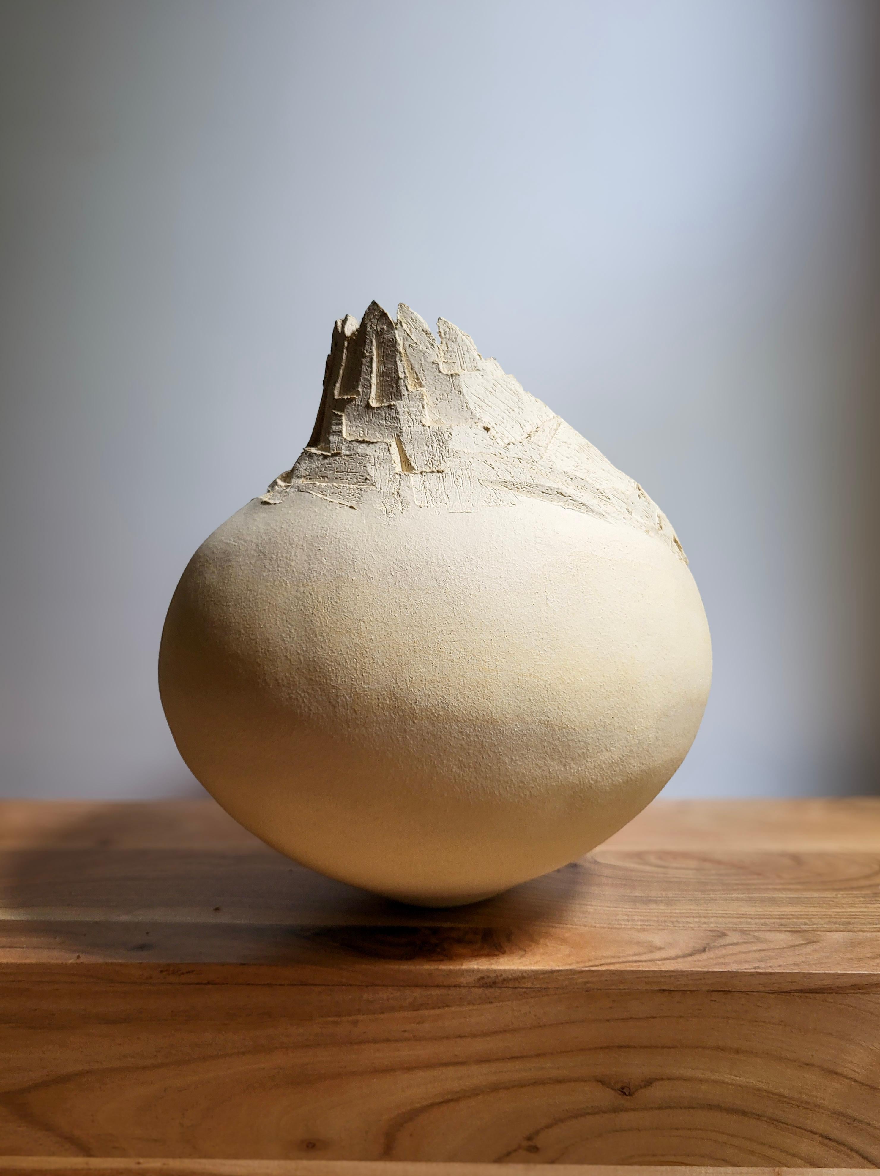 Erosion’s Memory III is a hand-built ceramic sculpture by French artist Audrey Vo Van, made from white chamotte stoneware. The form, both solid and delicate, evokes a weathered landscape — a fragment shaped by wind, water, and time. Its surface