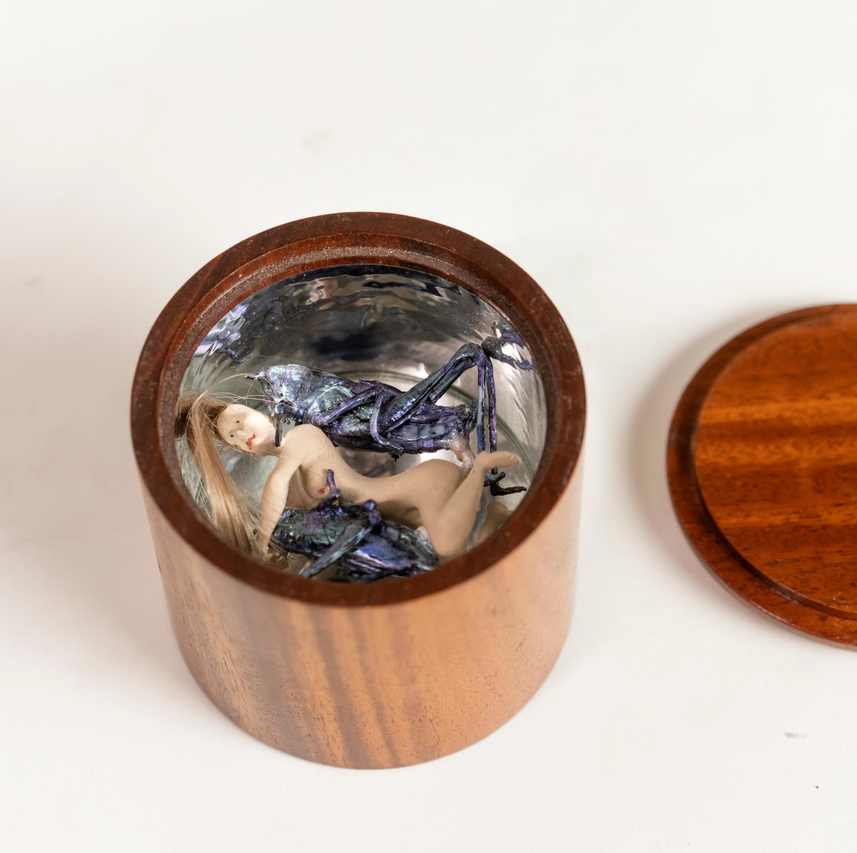 Erotic art work of a naked woman being enlaced by two crickets by Mark Prent resting in a circular walnut box with mirrored a liner signed under: 