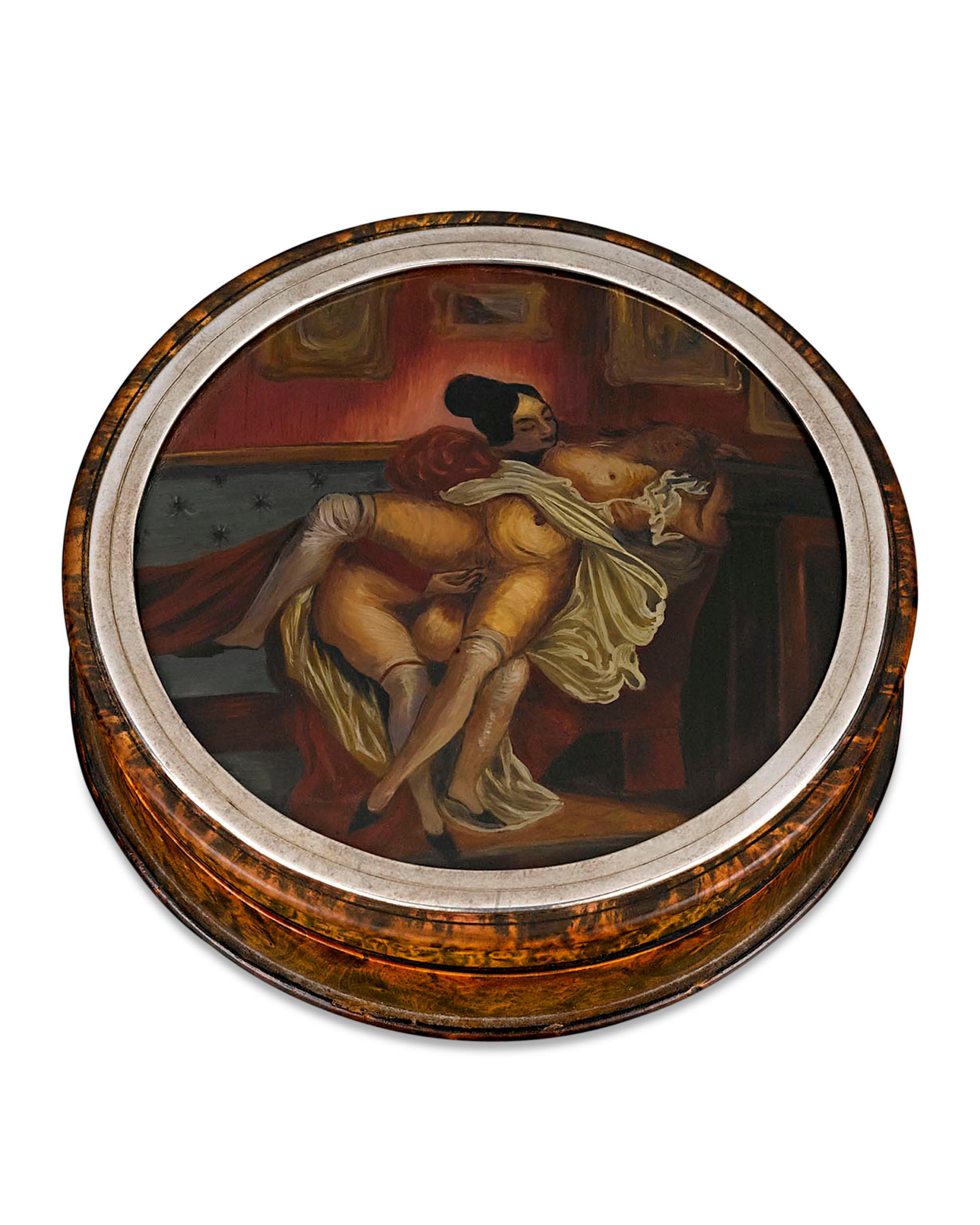 A scintillating Sapphic scene adorns the cover of this rare erotic snuff box. Set into the top of this burlwood and tortoiseshell container, this highly detailed tableau of two women in the throes of ecstasy is actually comprised of a base and