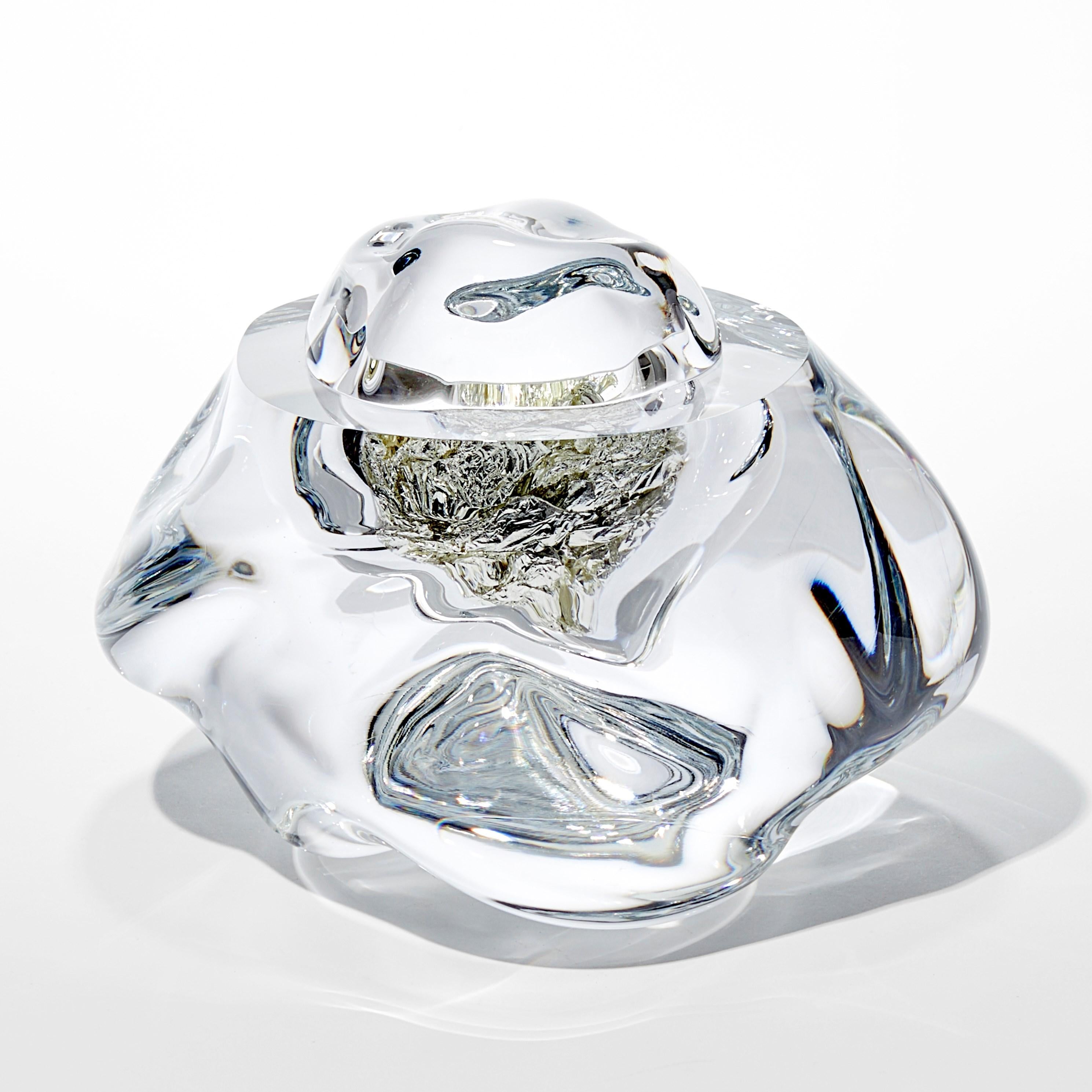 'Erratic K with 12ct White Gold' is a handblown and cut glass sculpture created by the British artist, Anthony Scala.

The geological term 'erratic' refers to a stone or boulder that differs to its surrounding rock, that is believed to have been