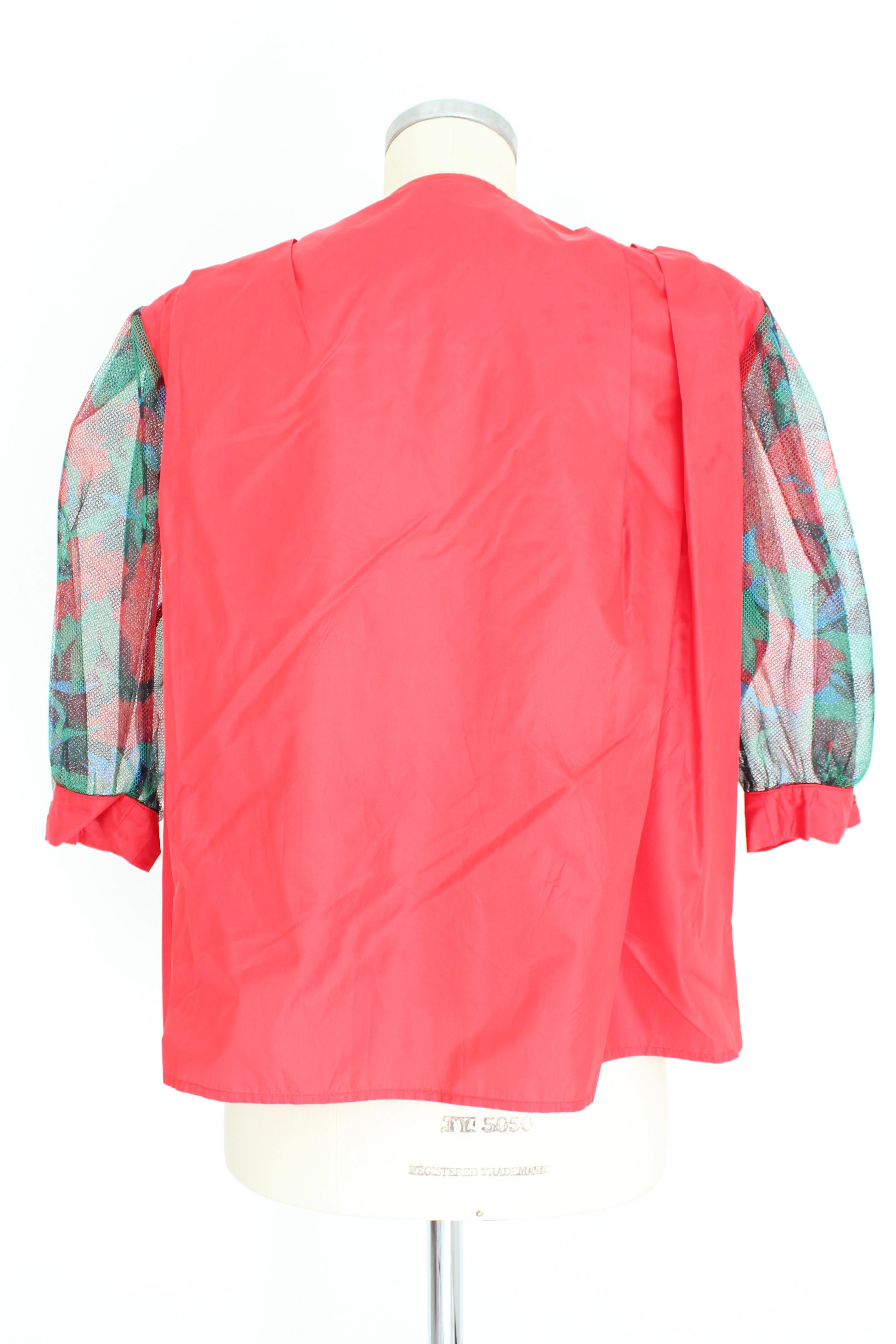 Camicia da donna vintage anni '80 di Erreuno. Camicia rossa, maniche a palloncino in microrete, colore verde con disegni floreali. Ampie spalline applicate. Tessuto 100% seta. Prodotto in Italia.

Condizioni: Eccellente

Articolo usato poche volte,