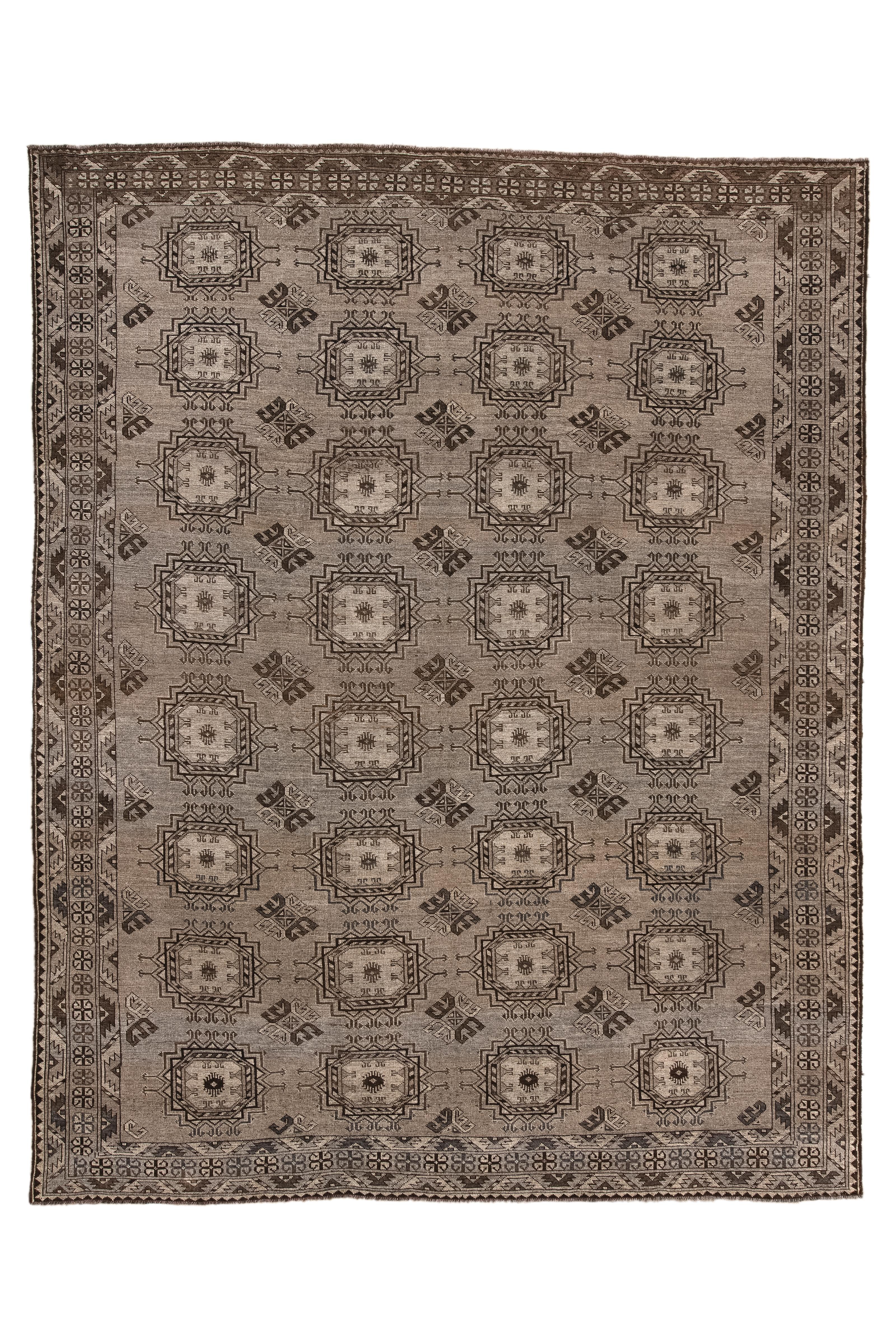 Le champ brun moyen de ce tapis nomade turkmène présente un ensemble de quatre par huit guls tribaux emblématiques de Merv avec des guls mineurs de Dynak en soutien. Bordures étroites avec une bande centrale brune de rosettes. Construction
