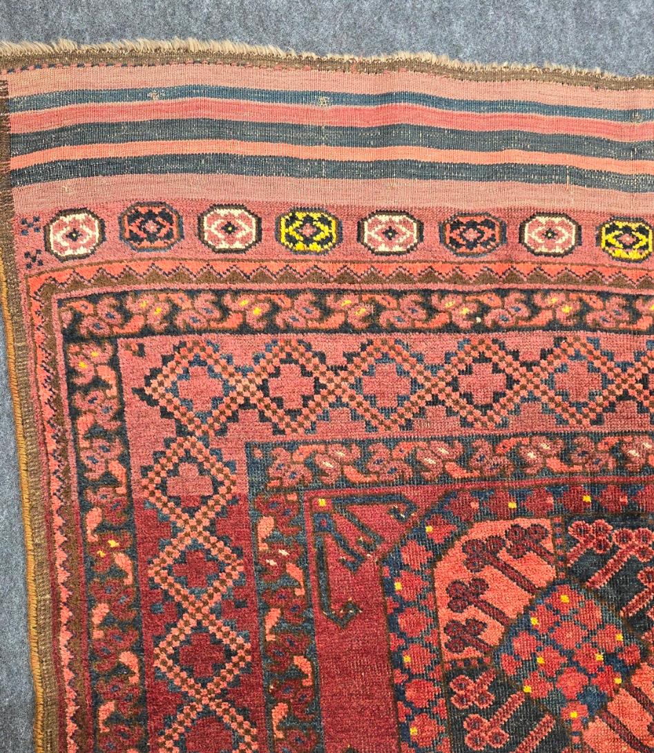 Descubre la belleza intemporal de esta alfombra turcomana Ersari antigua, fabricada en la década de 1900 y cargada de historia. Esta exquisita pieza tejida a mano, que mide 2,5 x 3 metros, refleja las ricas tradiciones de la tribu Ersari, conocida