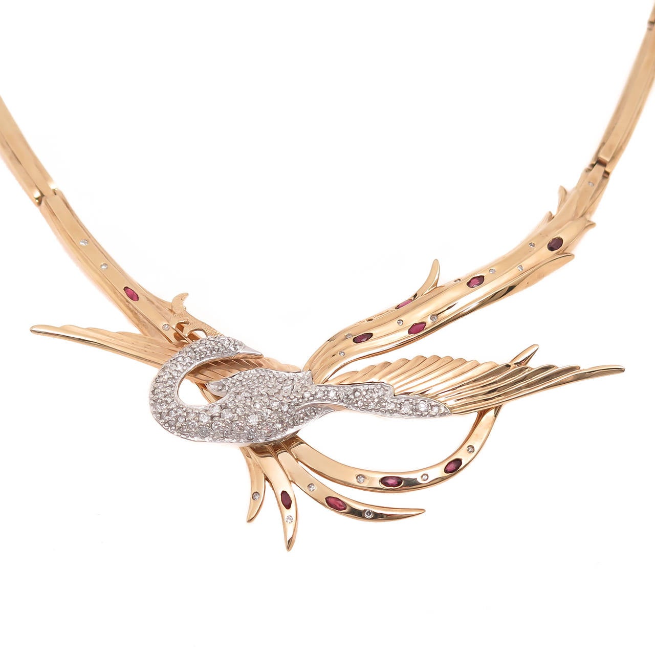 Circa 1980s Erte Juno 14K Yellow Gold Diamond and Ruby Bird Necklace which also breaks down to convert to a Brooch. Set with approximately 1 carat of Diamonds and further set with numerous oval Rubies. The Bird centerpiece of this necklace measures